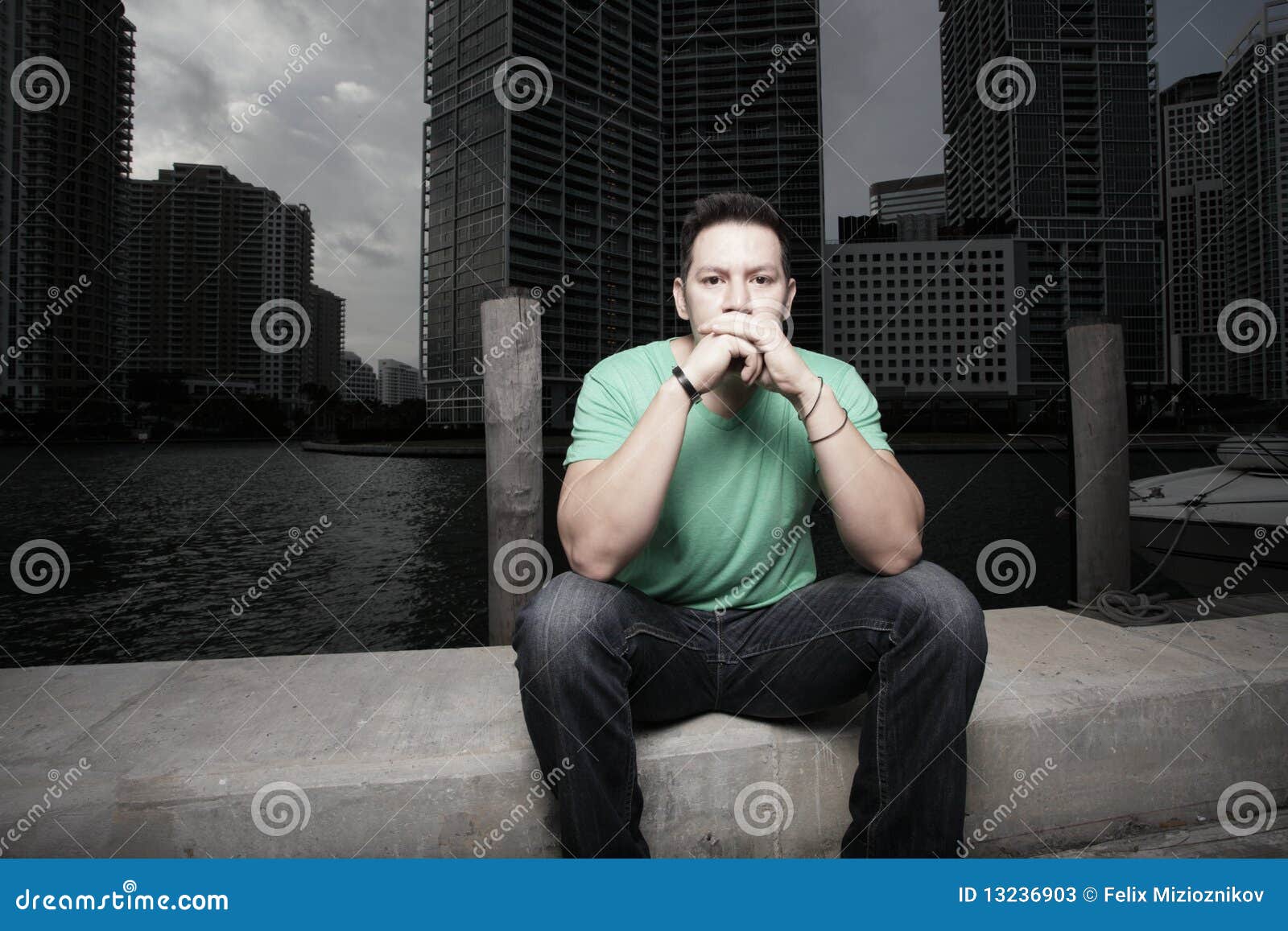 Man sitting alone and pondering. Young man sitting and pondering about life