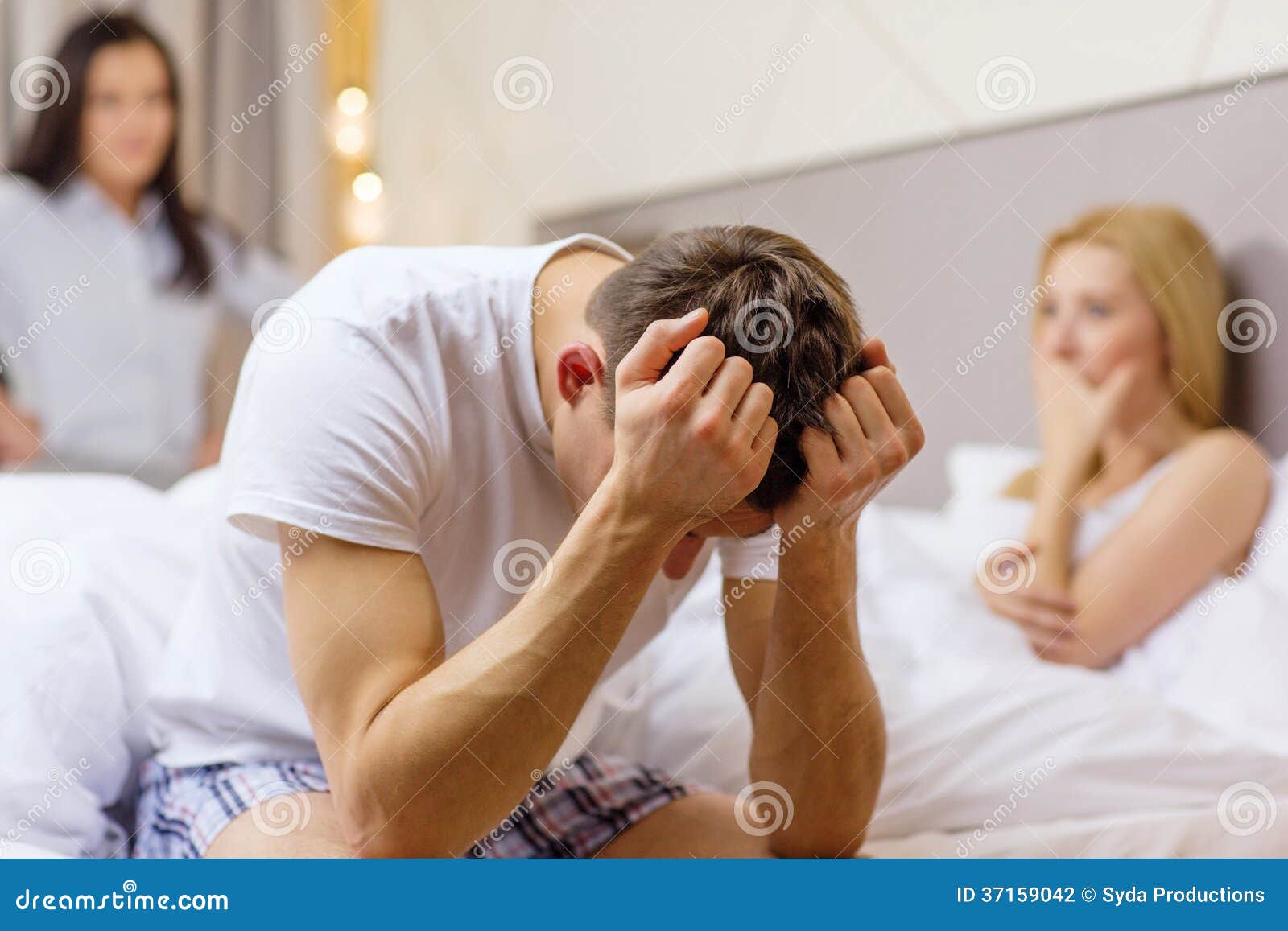 Man Sitting on the Bed with Two Women on the Back Stock Photo