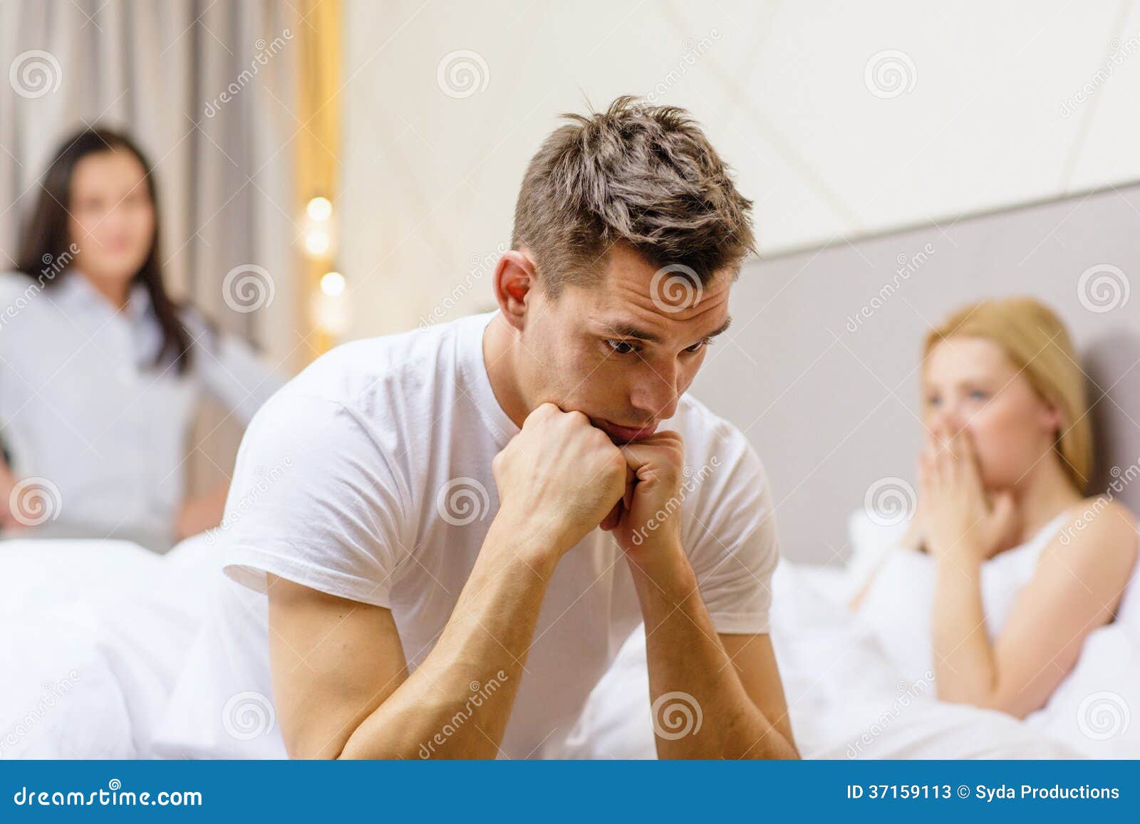 Man Sitting on the Bed with Two Women on the Back Stock Image photo