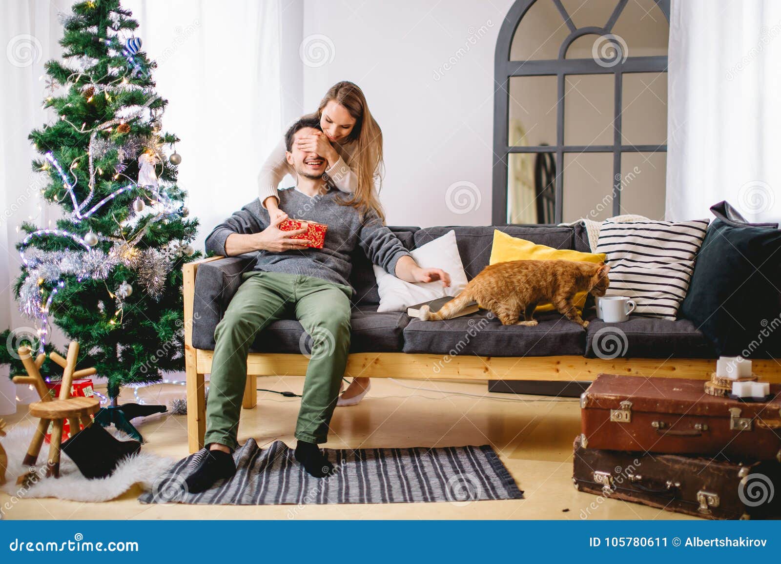 Christmas holiday couple happy young woman surprise boyfriend cover his eyes