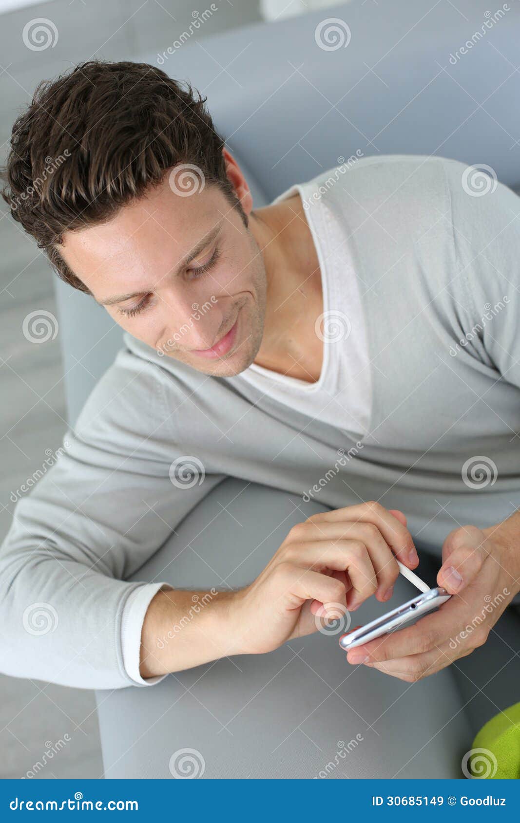 Man Sitting in Couch Using Smartphone Stock Image Image of male