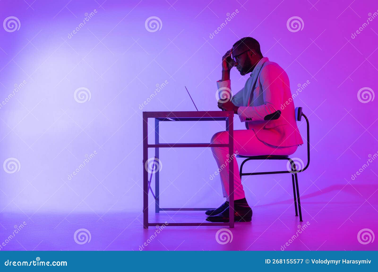 A Man is Sitting at a Desk. a Black Programmer Works Using a Laptop