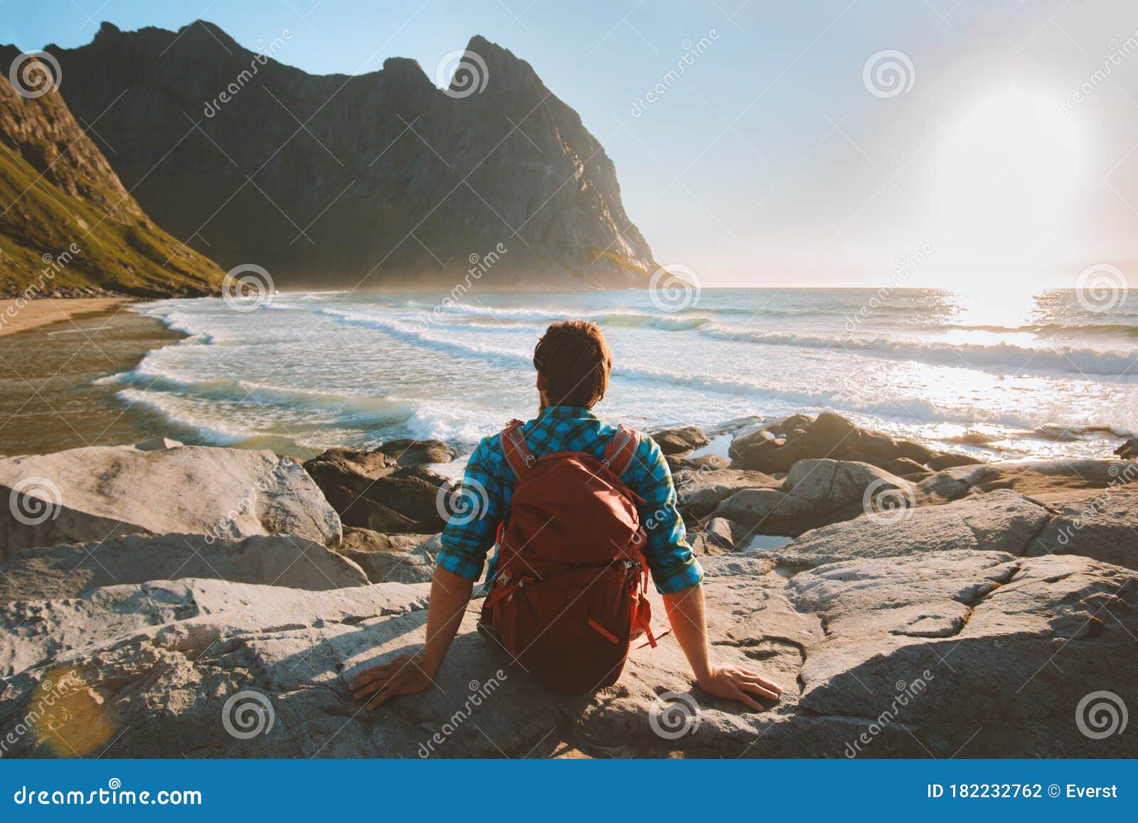 man sitting on kvalvika beach enjoying ocean view travel vacations eco tourism