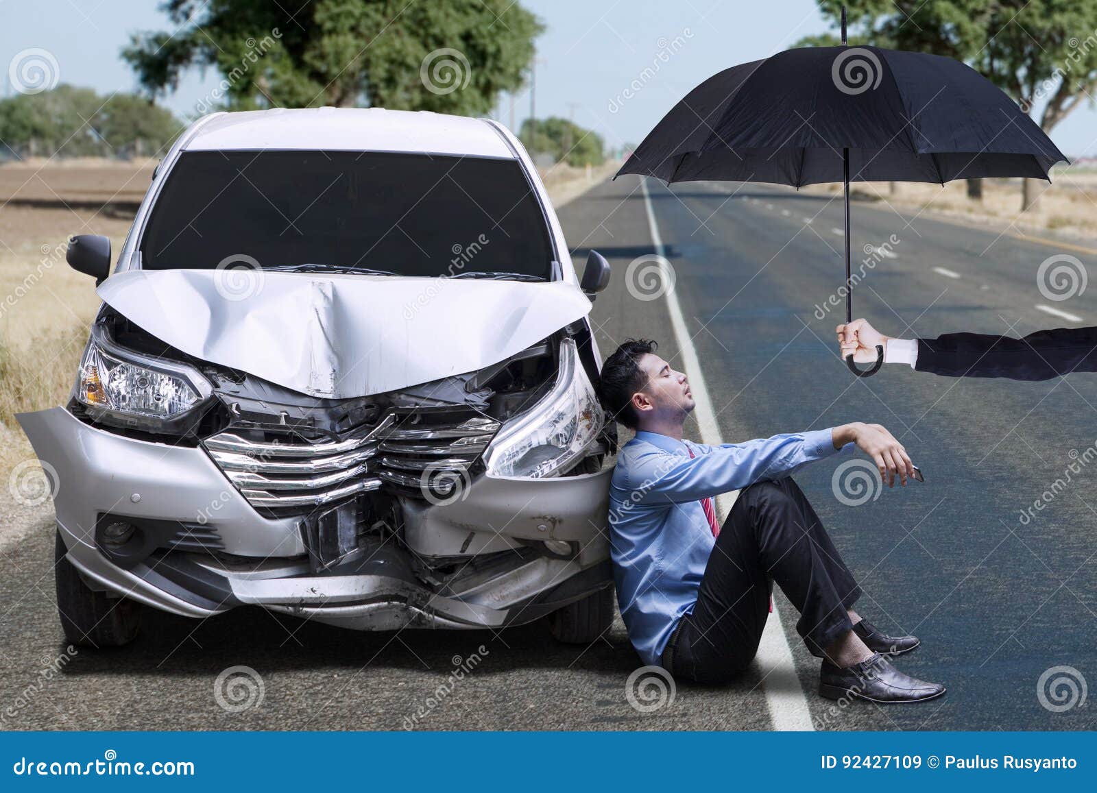 man sitting next to dented car