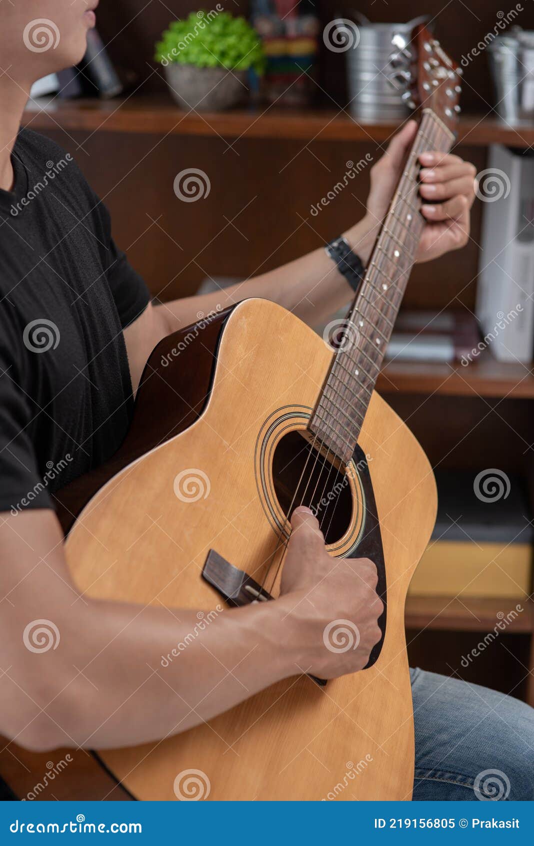 A Man Sitting and Playing Guitar on a Chair Stock Image Image of