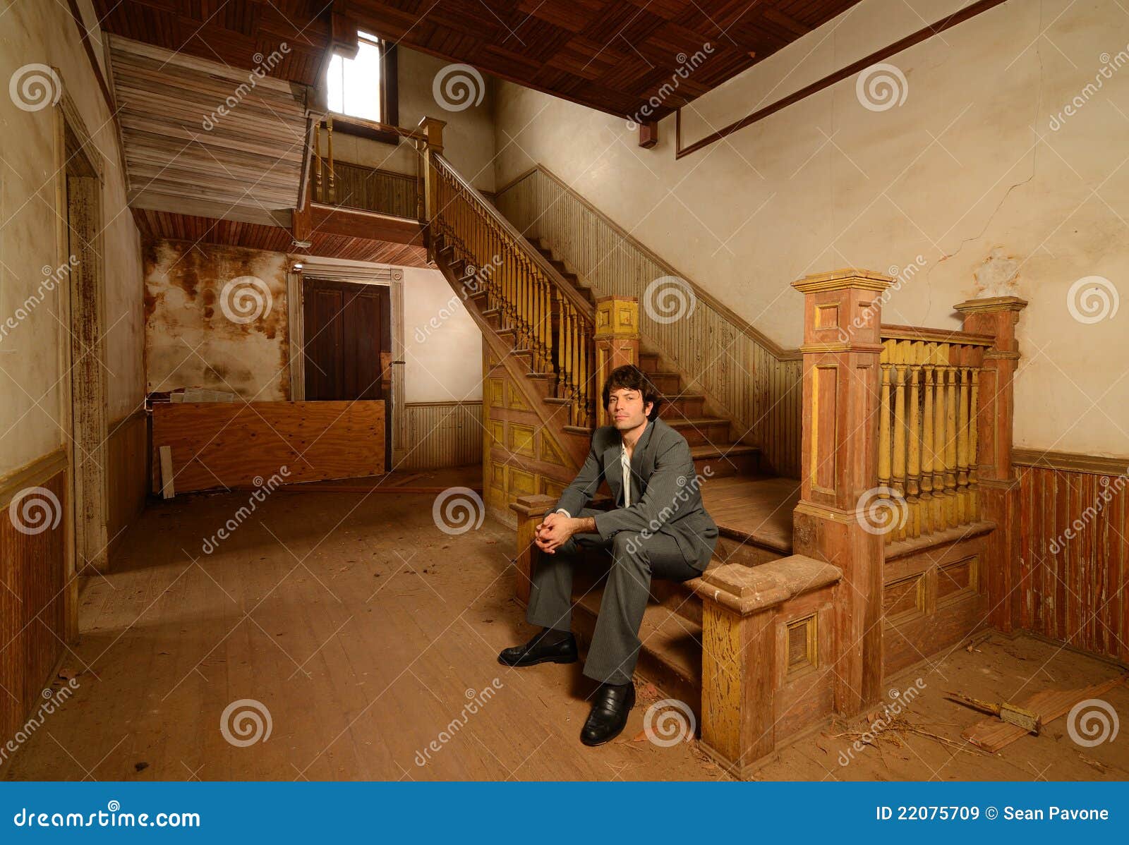 Man Sitting On Stairs In An Old House Stock Image - Image 