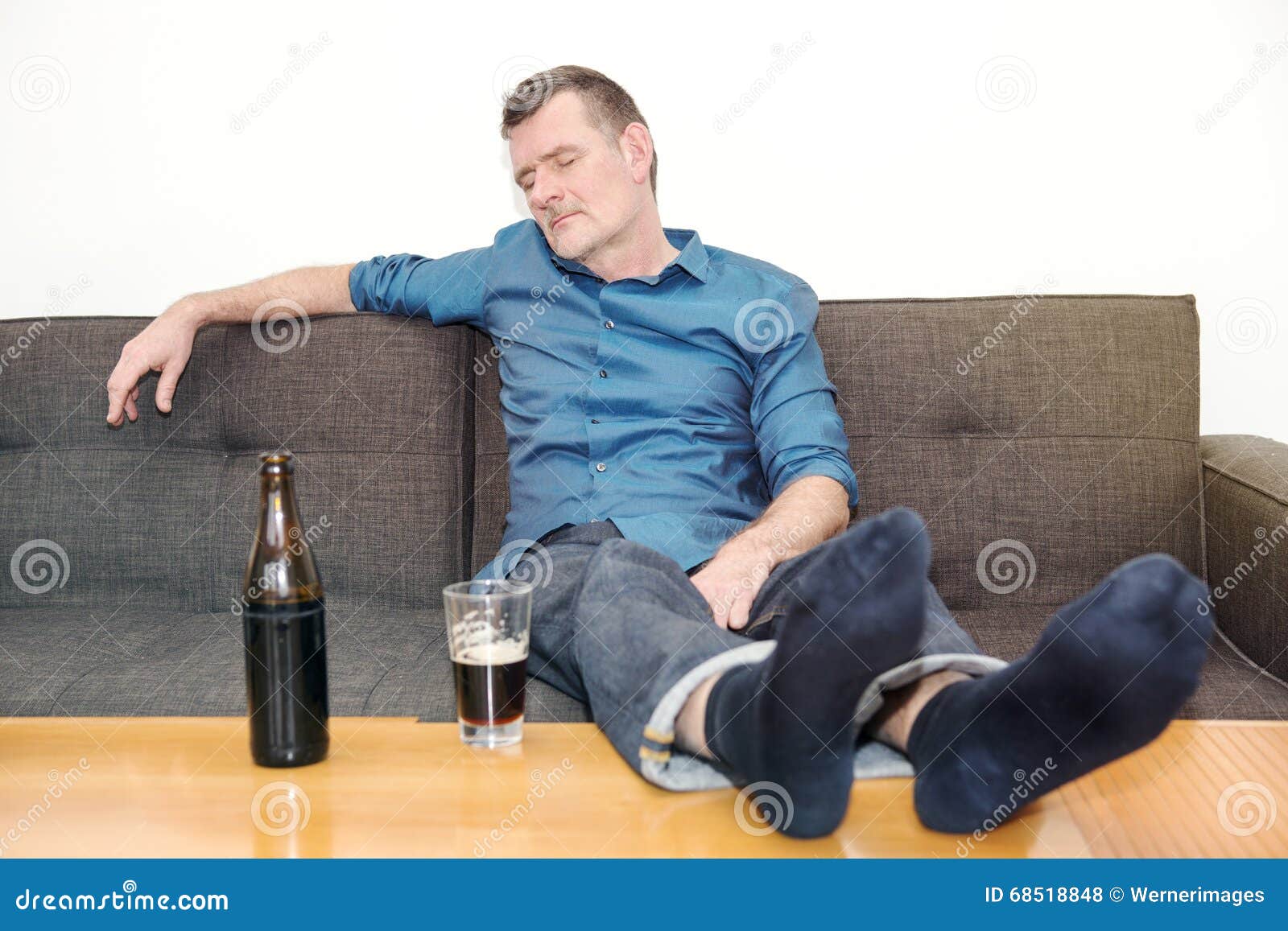 Man Sleeping on Couch with Bottle of Beer on Table Stock Photo - Image ...