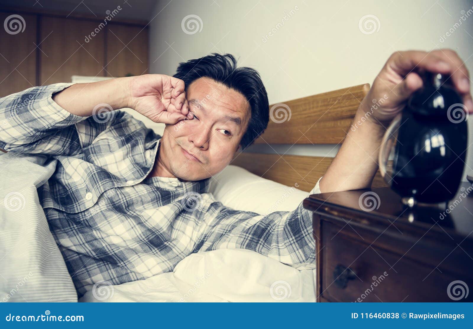 a man sleeping soundly waking from alarm