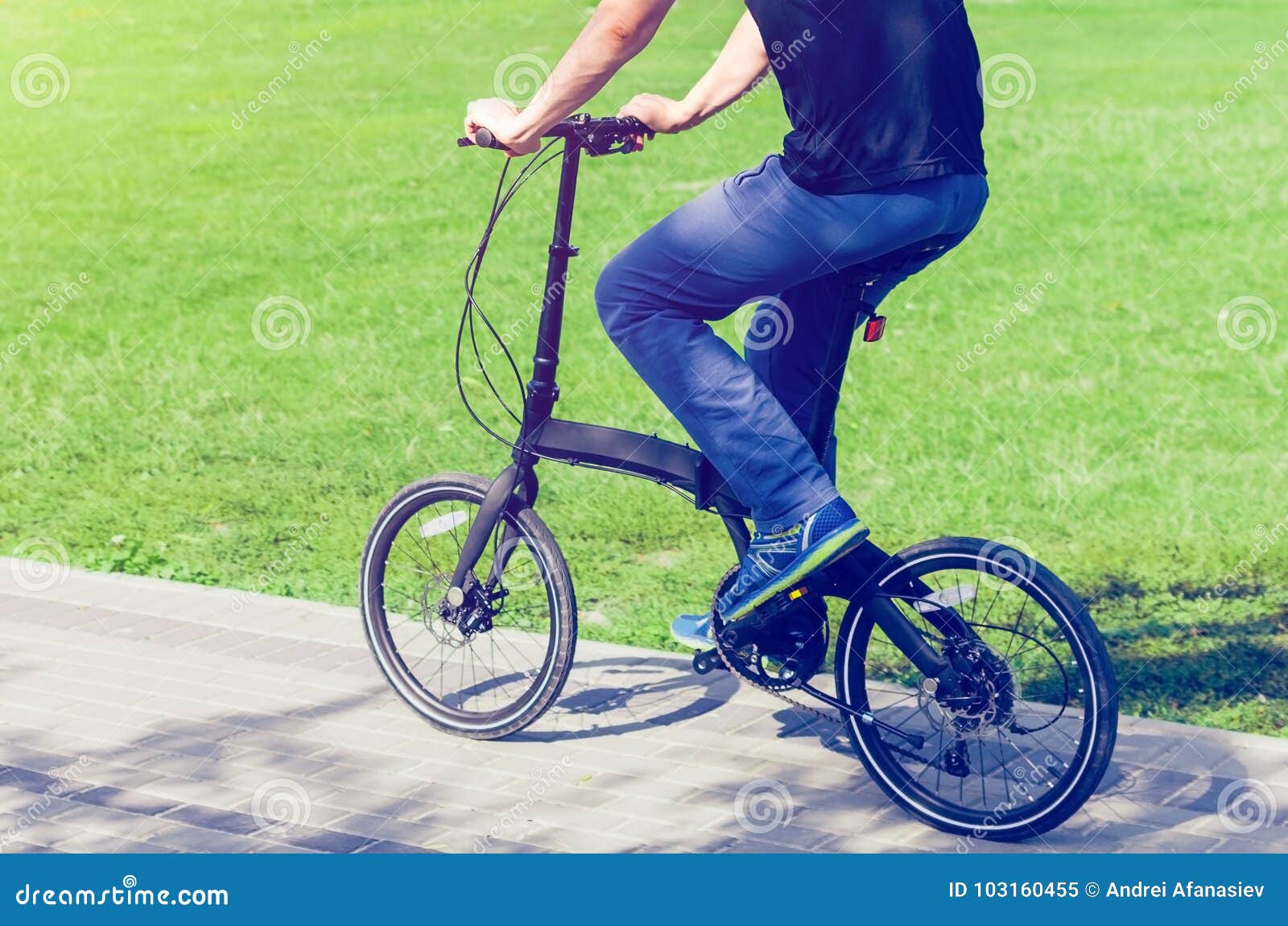 A Man on a Small Bicycle Riding a Bicycle Path Stock Image Image of