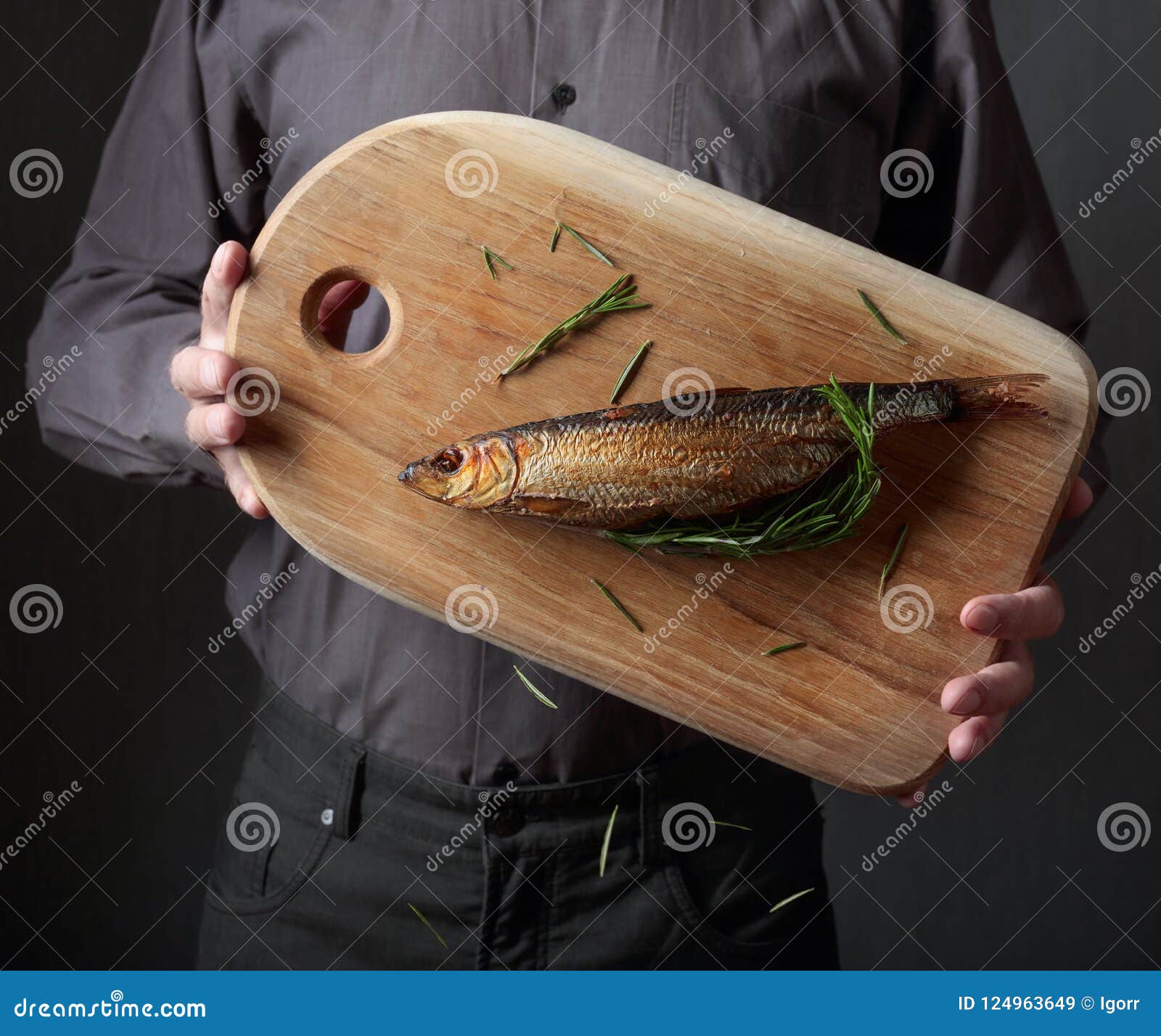 Man with smoked herring . stock image. Image of holding 124963649