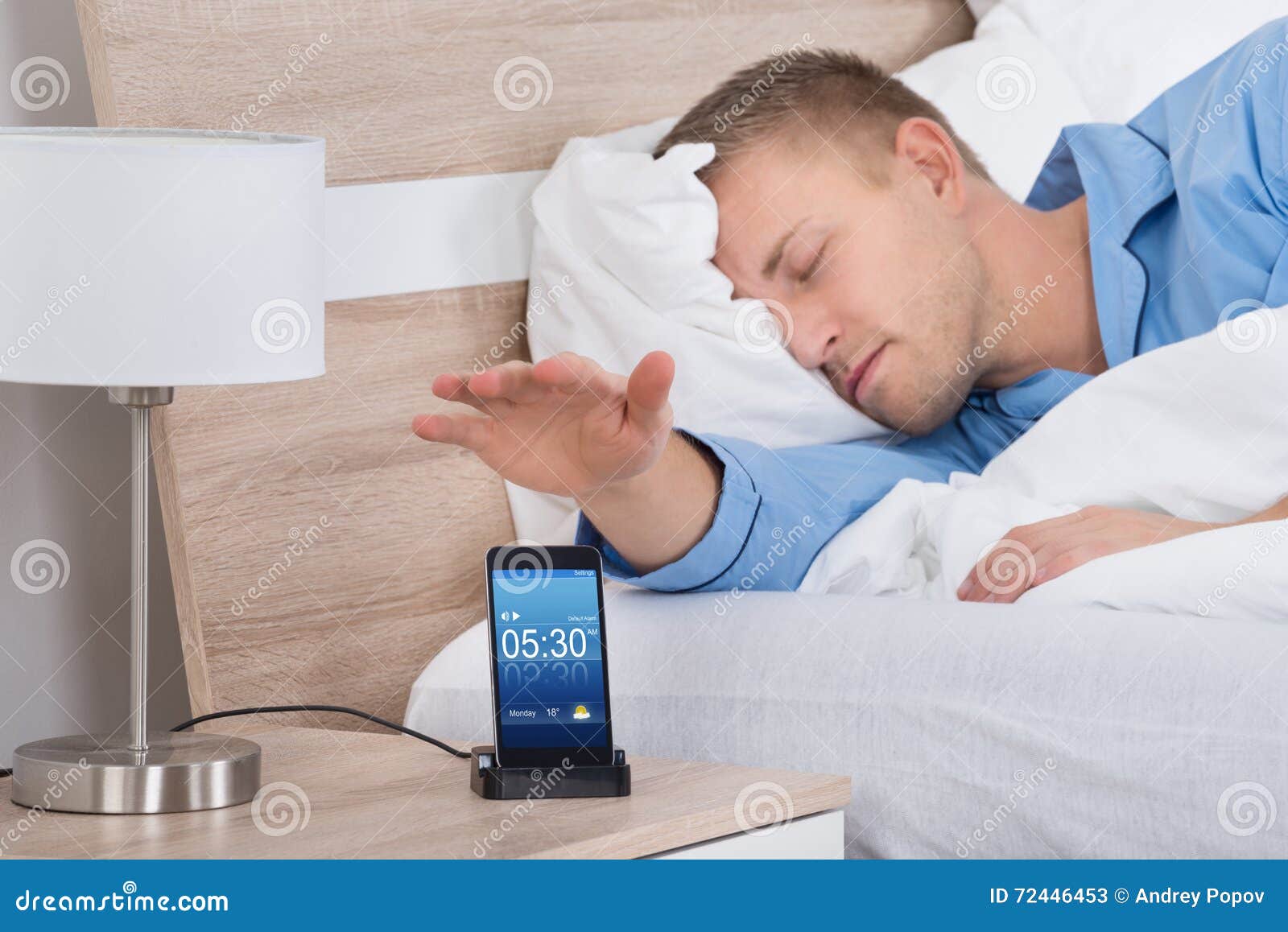 man snoozing alarm on mobile phone screen