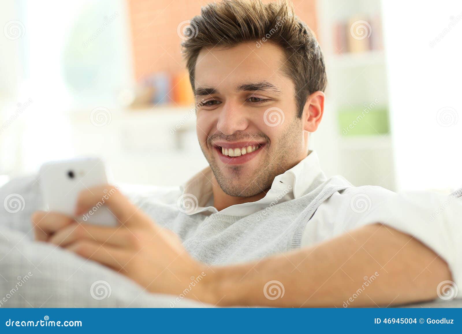 Man in Sofa Using Smartphone Stock Photo Image of sitting,