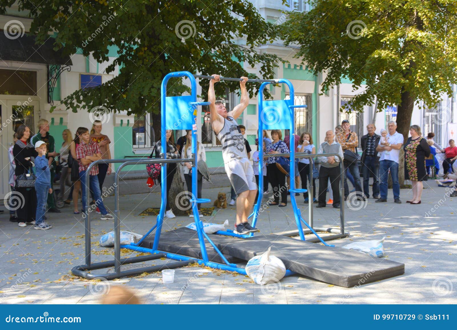 A Man in the Square Does Gymnastic Exercises on Uneven Bars Editorial