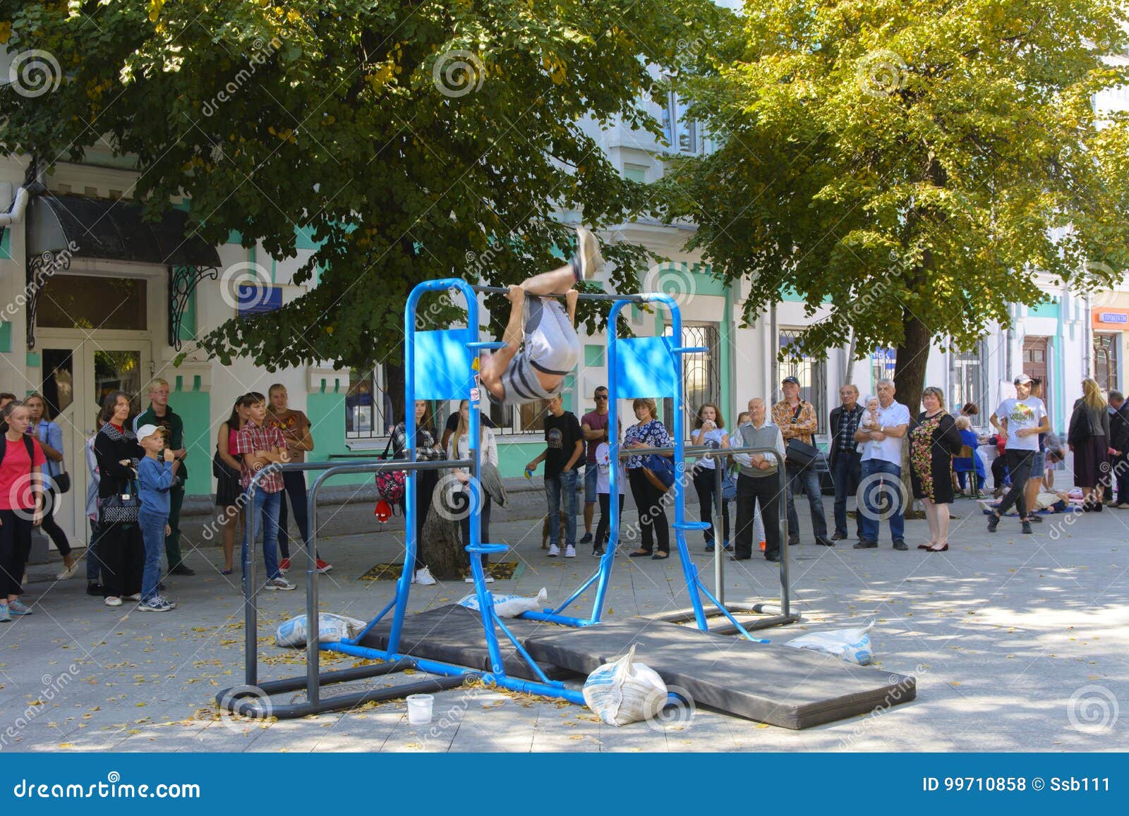A Man in the Square Does Gymnastic Exercises on Uneven Bars Editorial