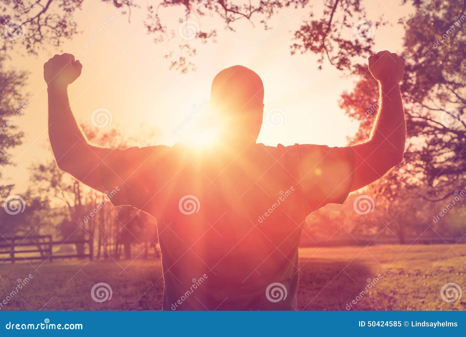 man standing with arms raised in victory gesture