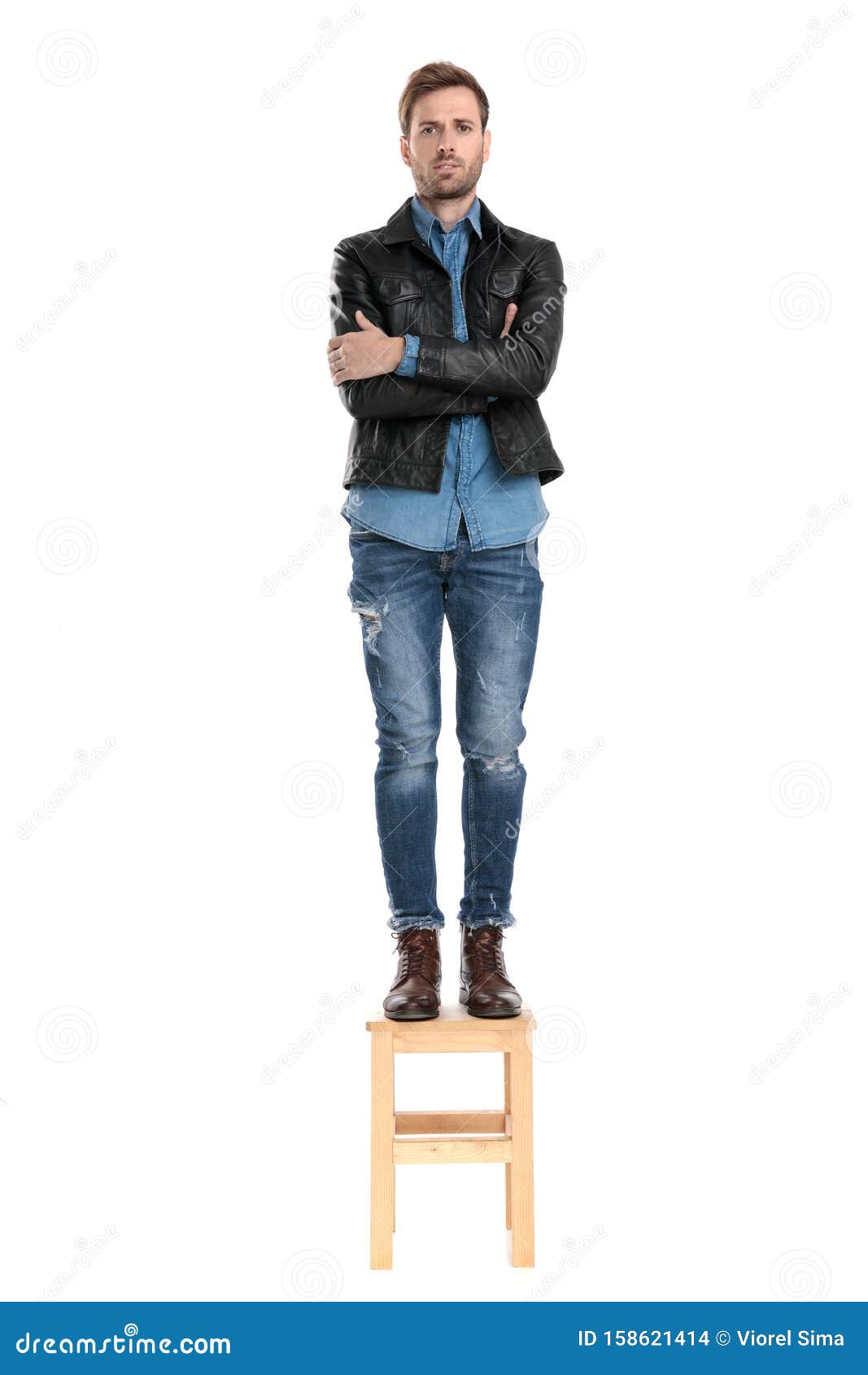 man standing on chair with arms crossed stock photo  image