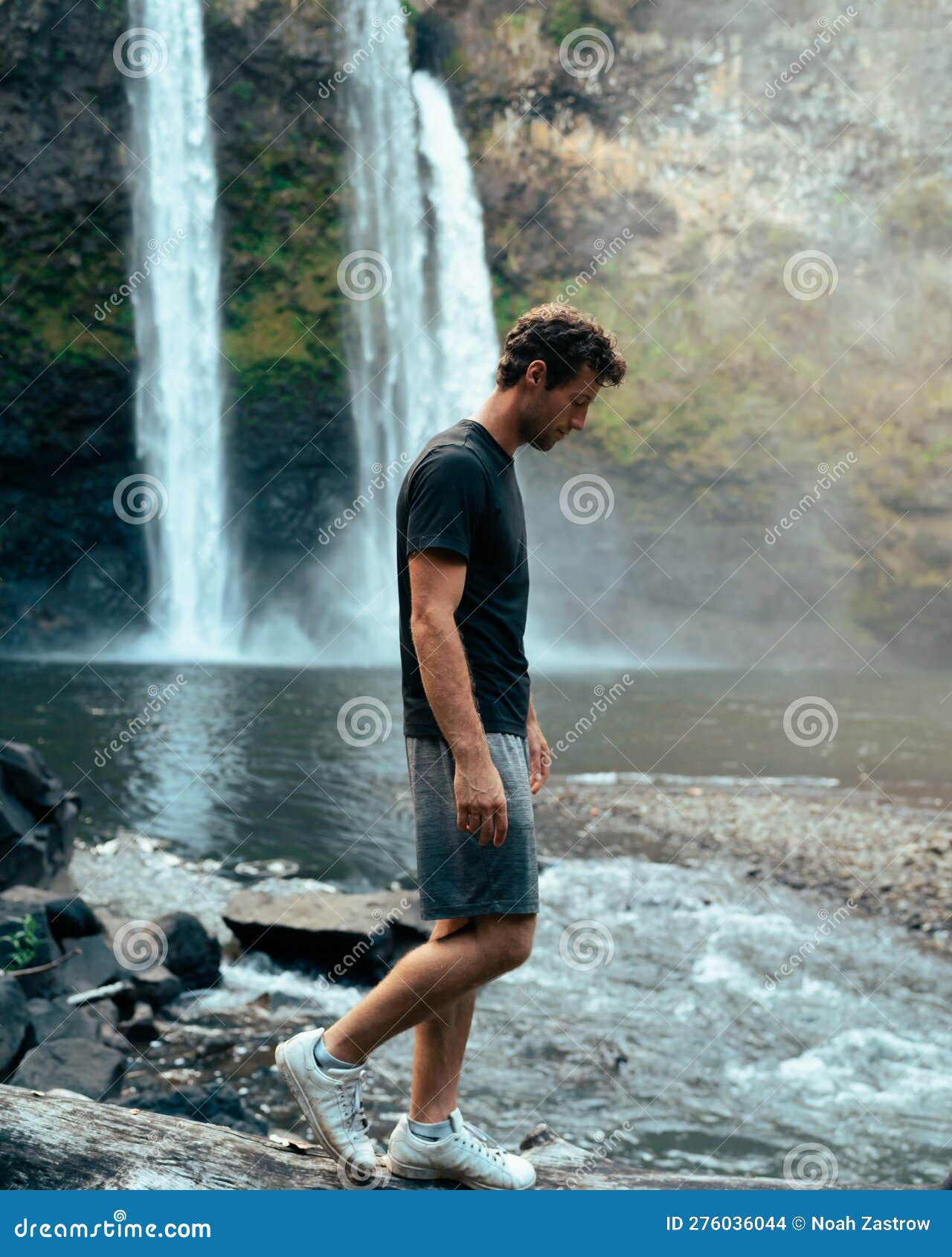 Portrait of young girl near waterfall. Young lady poses against background  of water falling from the cliff, overgrown with grass, bushes and forest. P  Stock Photo - Alamy