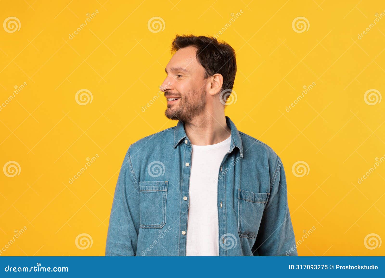 man standing in front of yellow background, looking aside