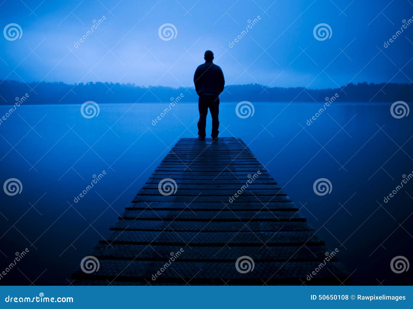 man standing on a jetty by tranquil lake concept