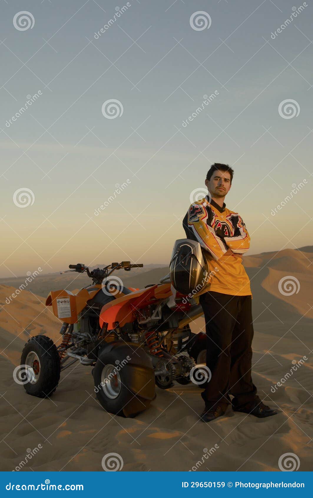 Man Standing by Quad Bike stock image. Image of terrain 29650159