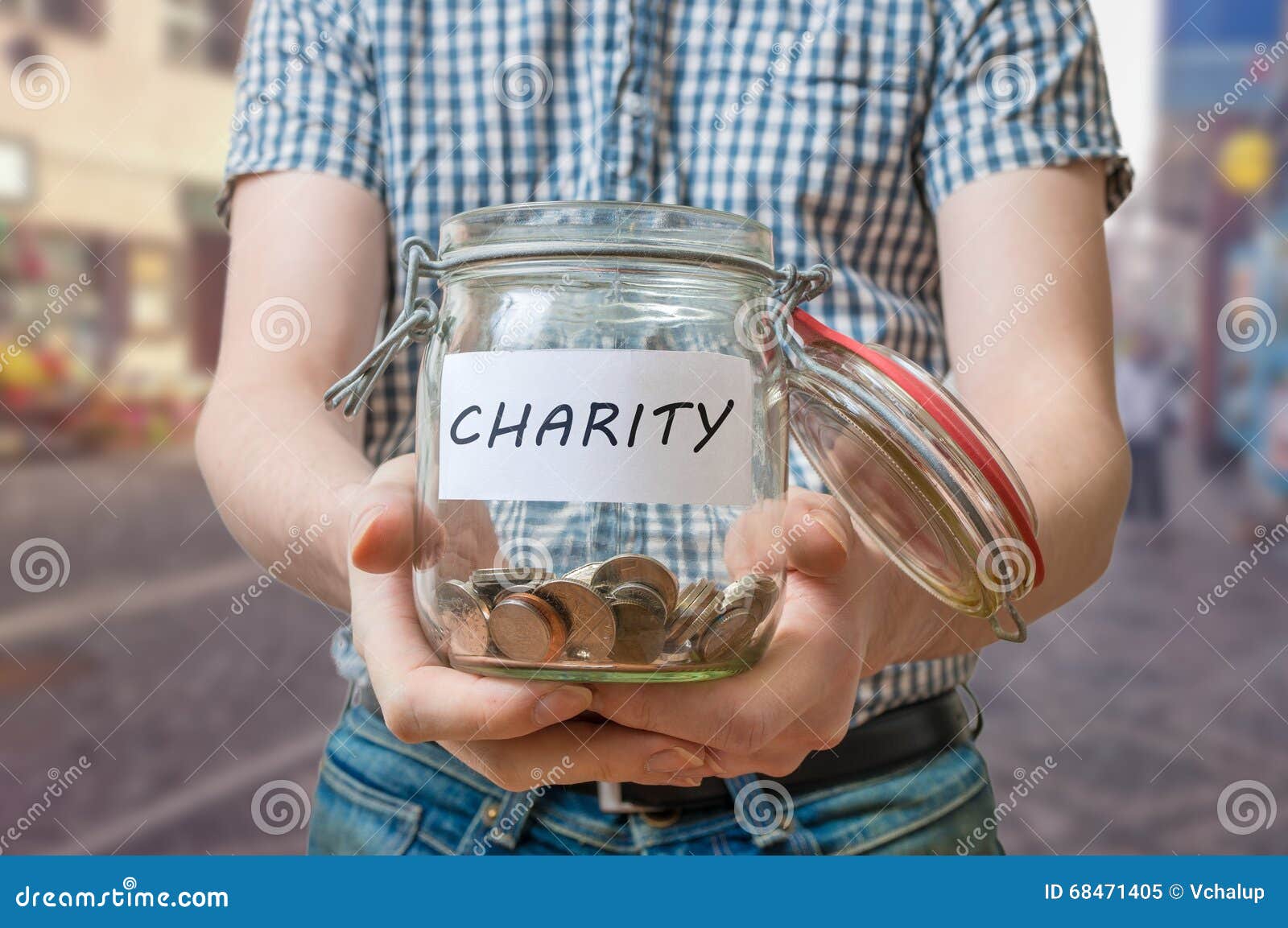 man standing on street is collecting money for charity and holds jar