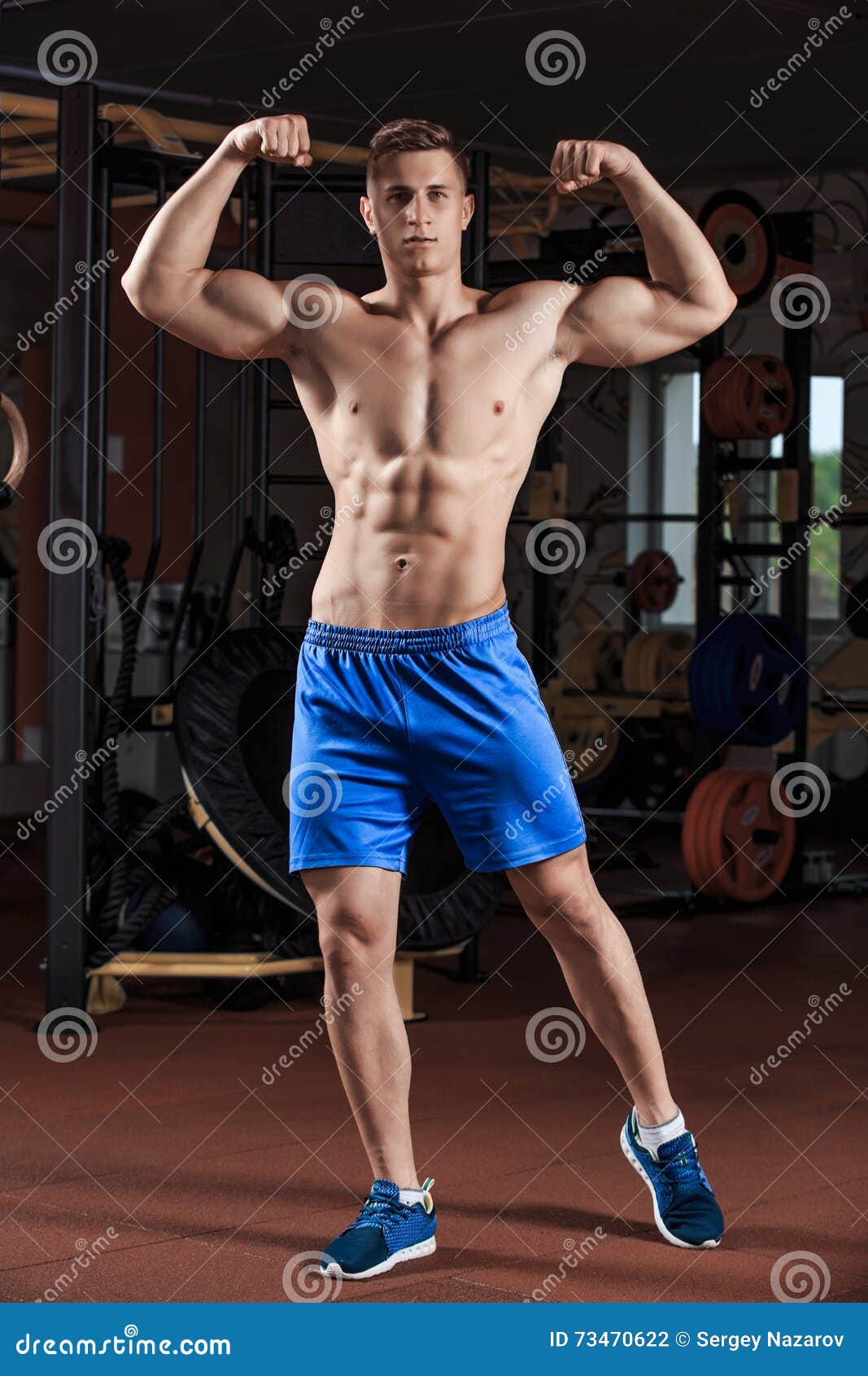 Man Standing Strong In The Gym And Flexing Muscles Stock Photo - Image