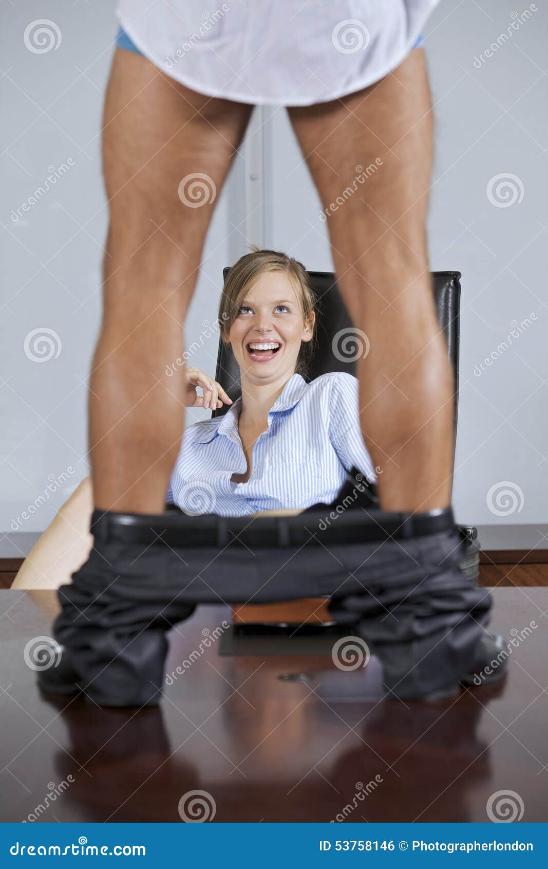 man standing on table with trouser down, flirting with businesswoman in office