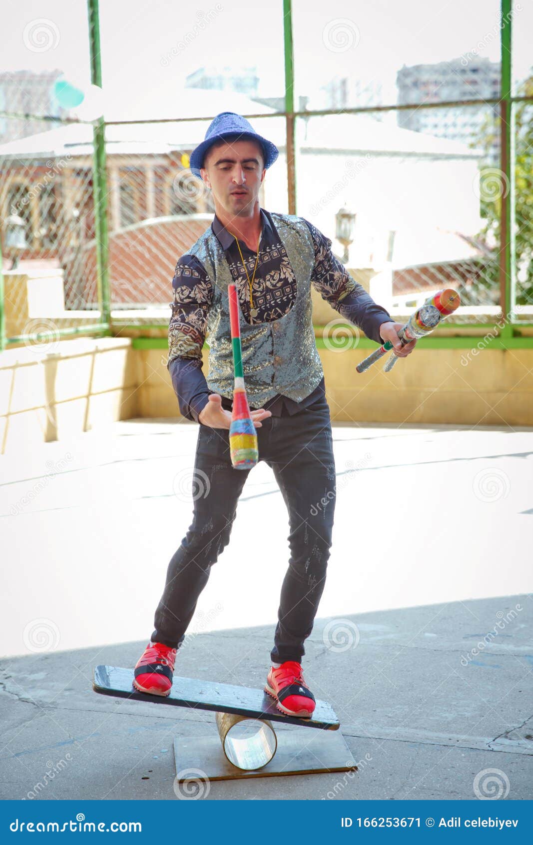 Man Standing on Top of Cylinders and Juggling Glass Bottles, One Bottle ...