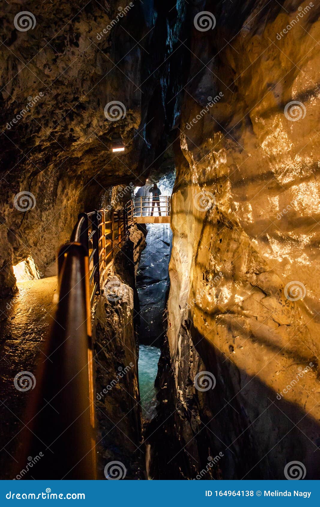 man standing in trummelbach falls, the biggest waterfall in europe, inside a mountain accessible for public, lauterbrunnen village