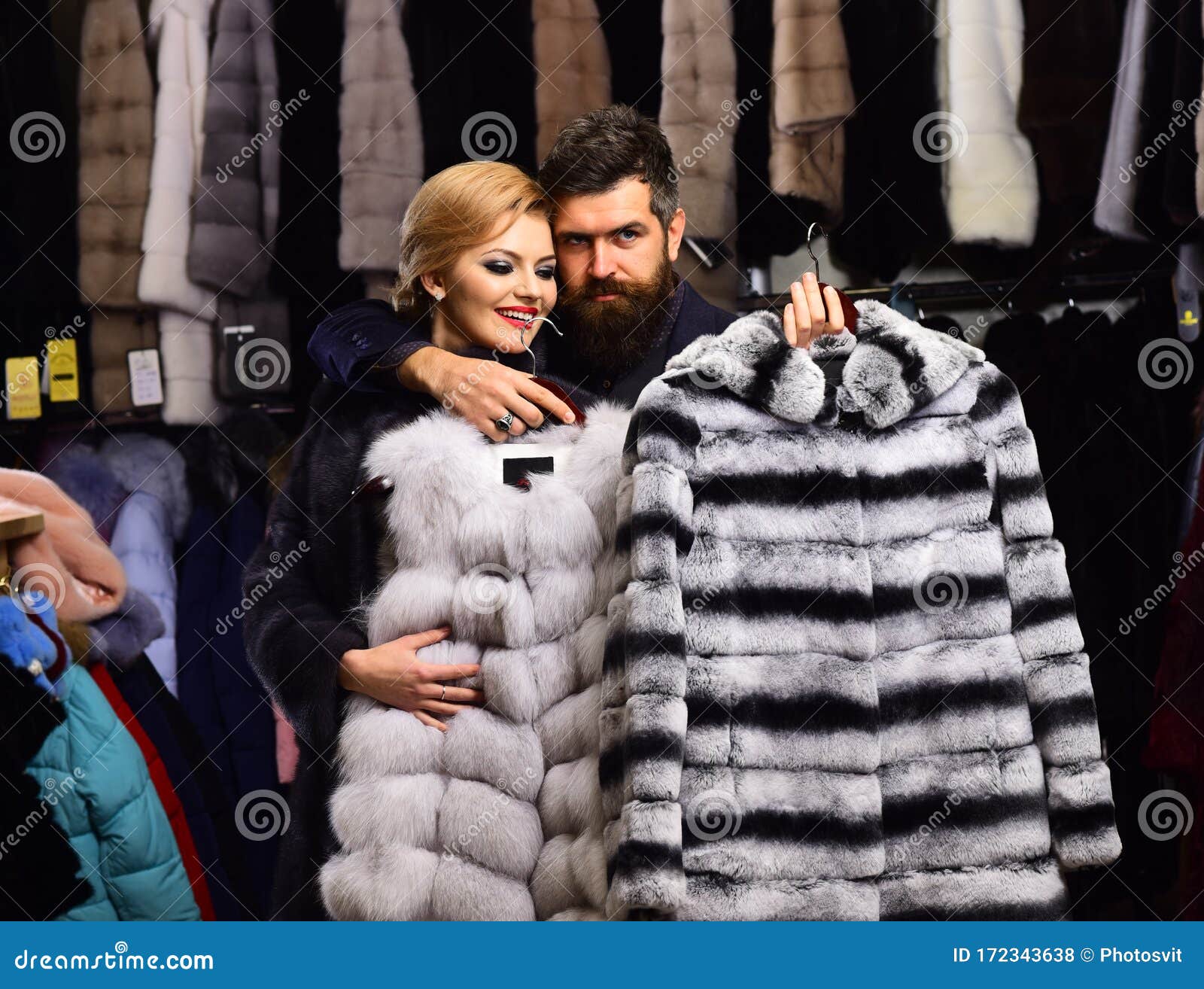 Man with Strict Face and Woman with Coats in Shop. Stock Photo - Image ...
