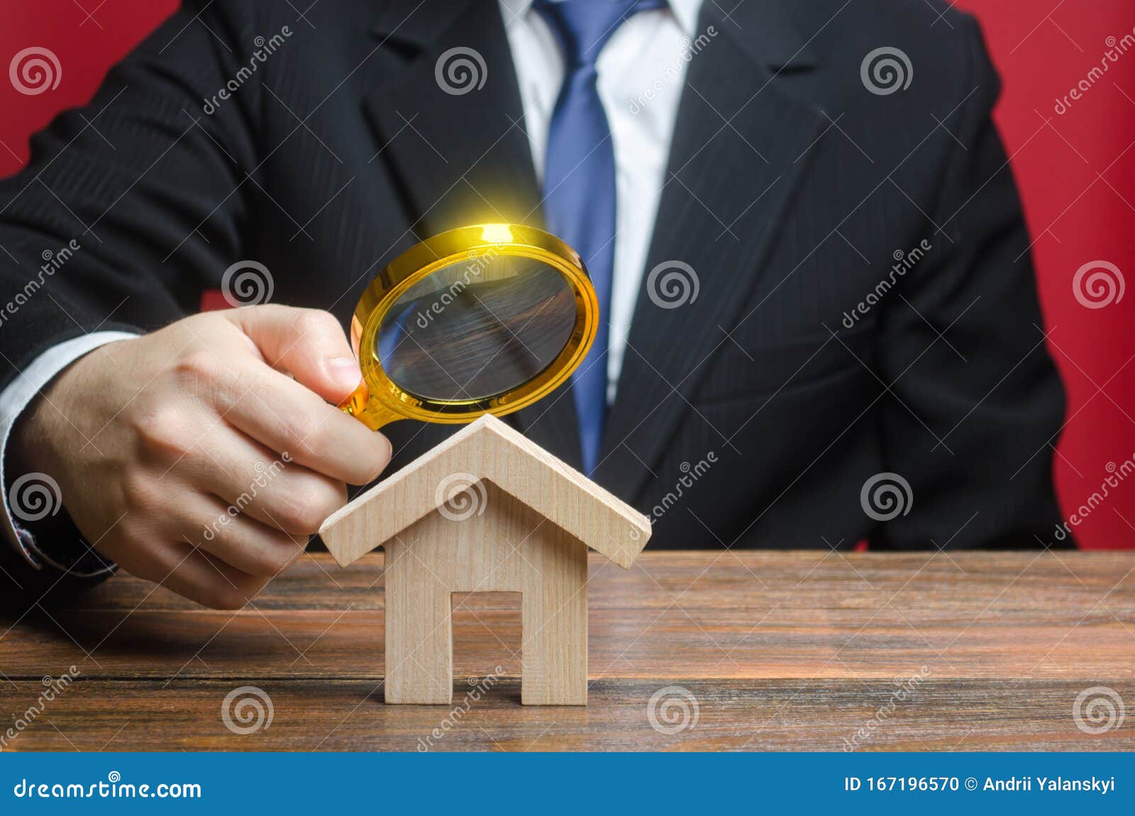 a man is studying a house through a magnifying glass. fair value of real estate. property valuation. legal deal. legality and
