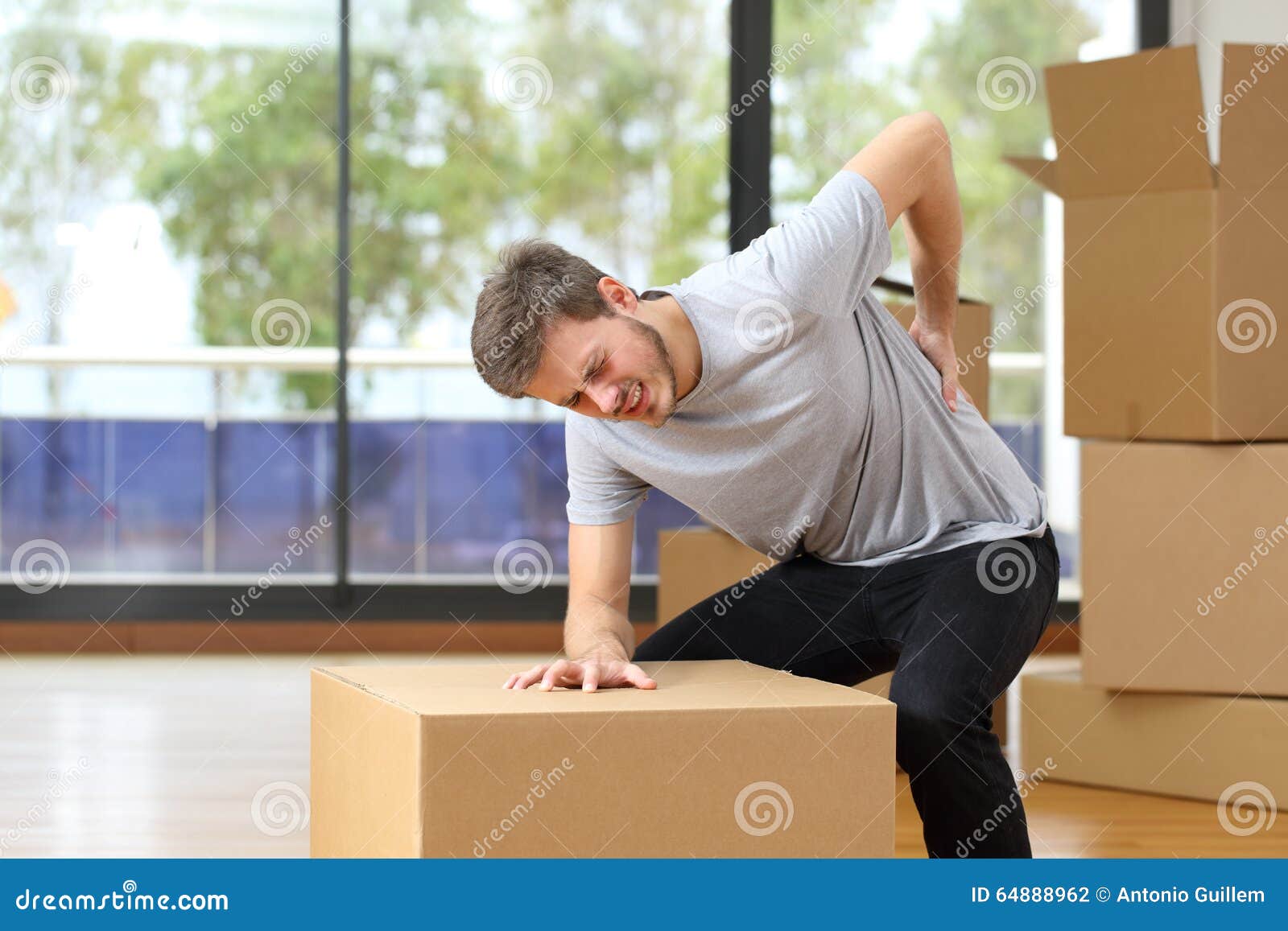 man suffering back ache moving boxes