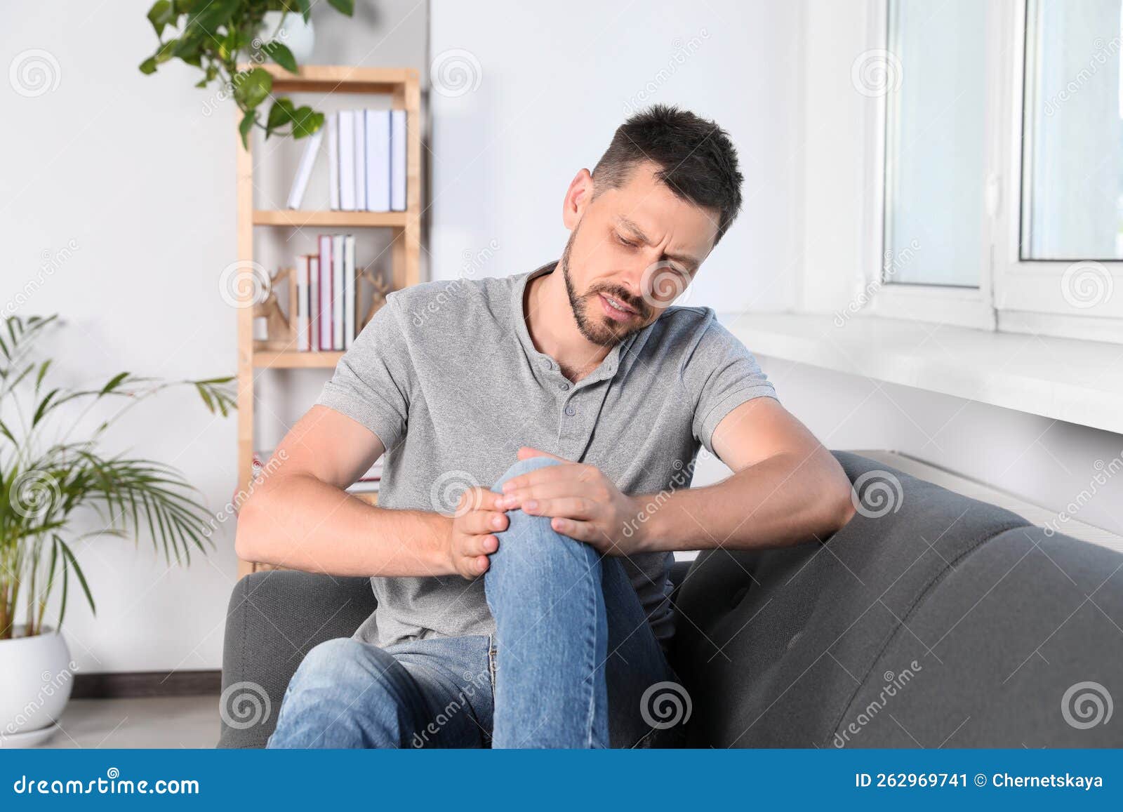 Man Suffering from Knee Pain on Sofa at Home Stock Image Image of