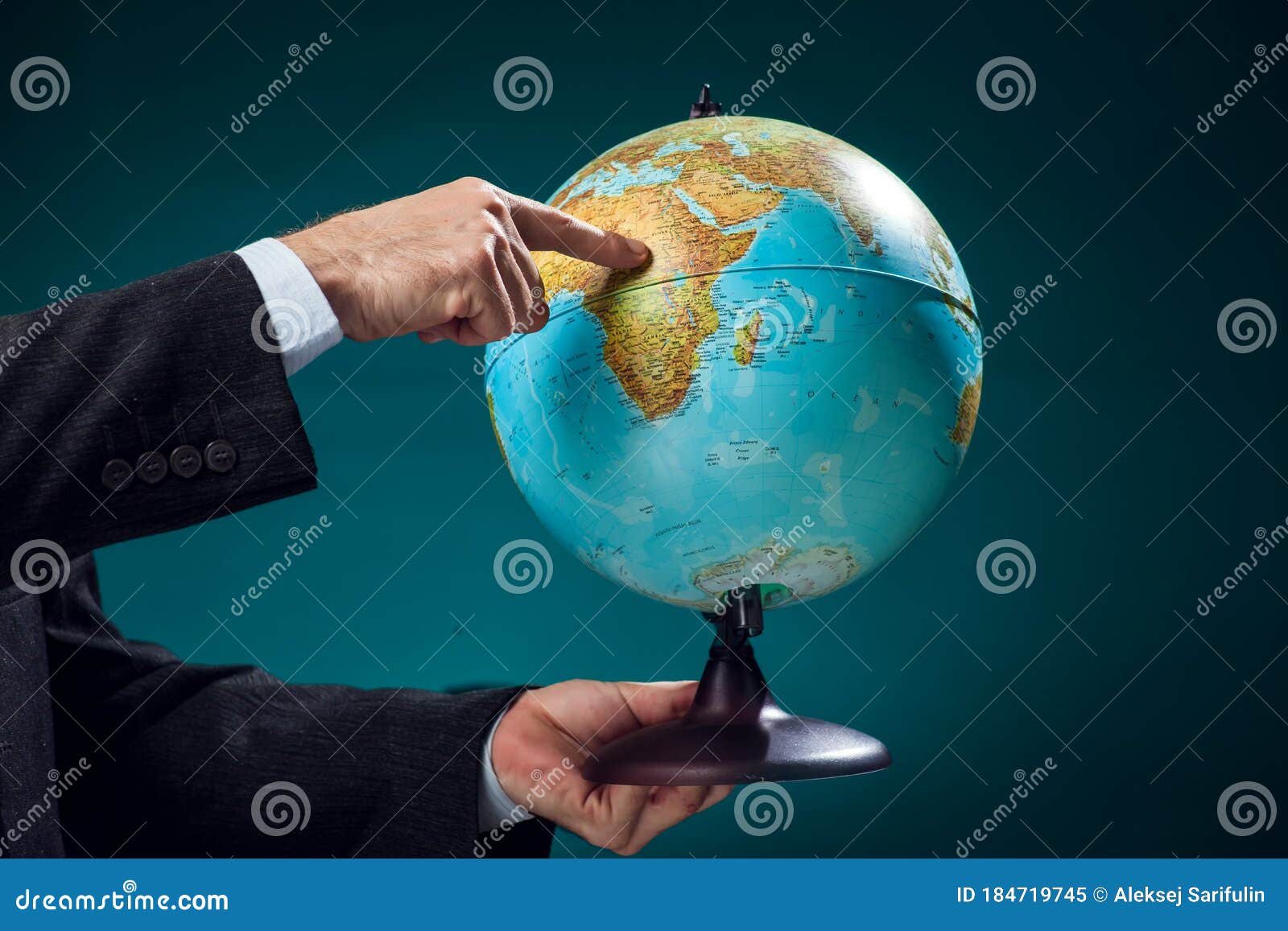 A Man In Suit Holding Globe And Pointing At Africa