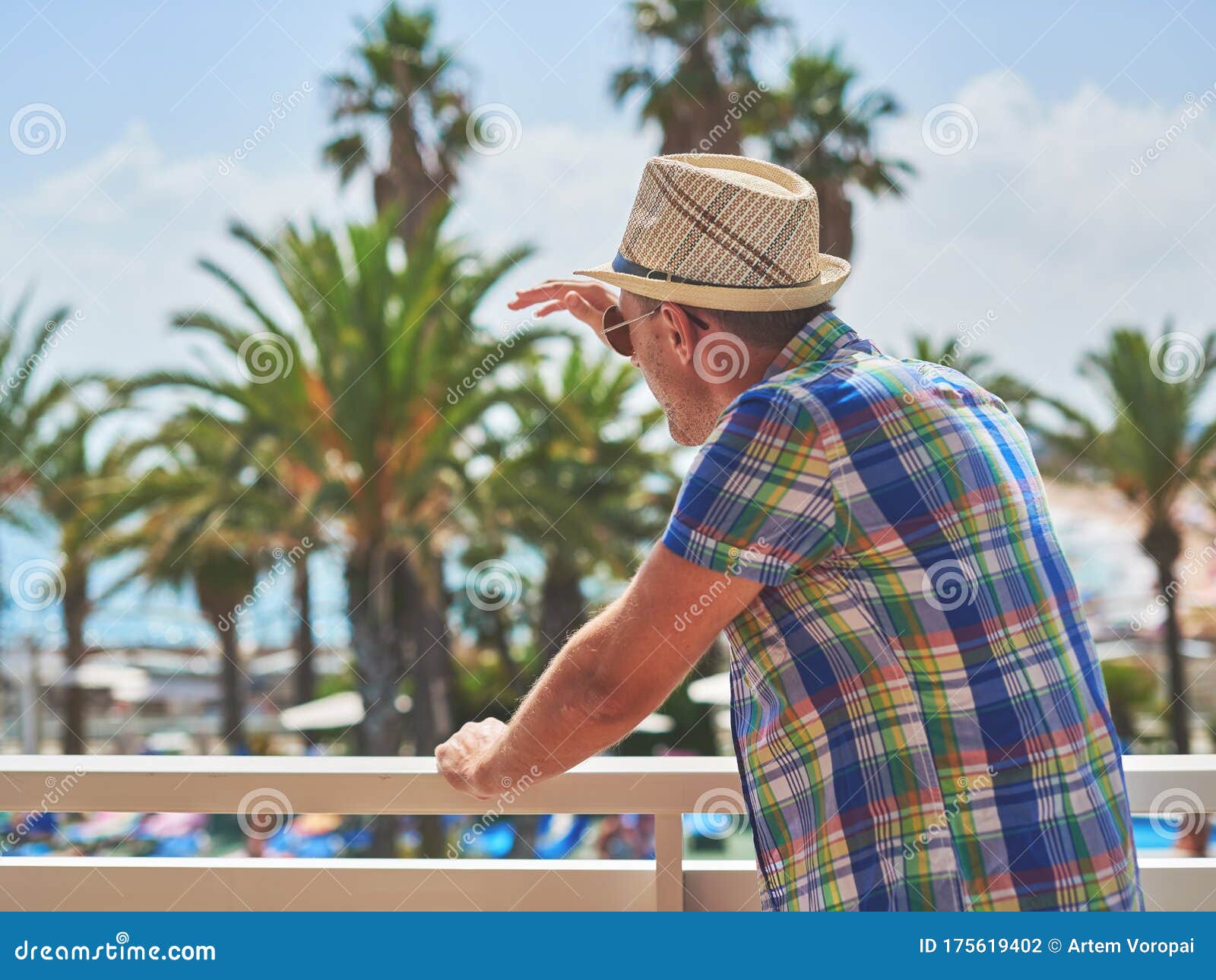 man in sunhat watching at picturesque sea view