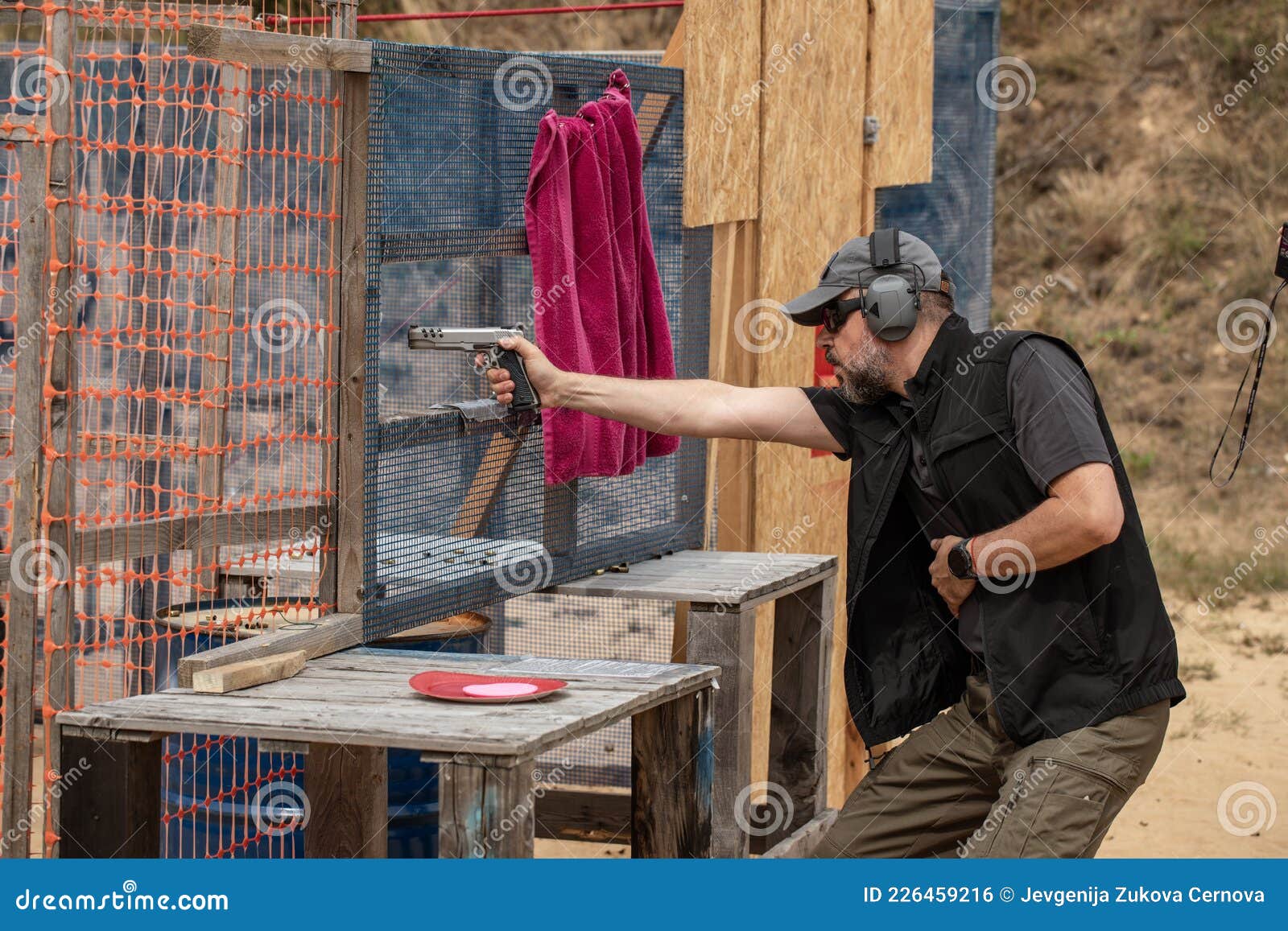 Man in Tactical Clothes Shooting from a Pistol, Reloading the Gun and Aiming at the Target in