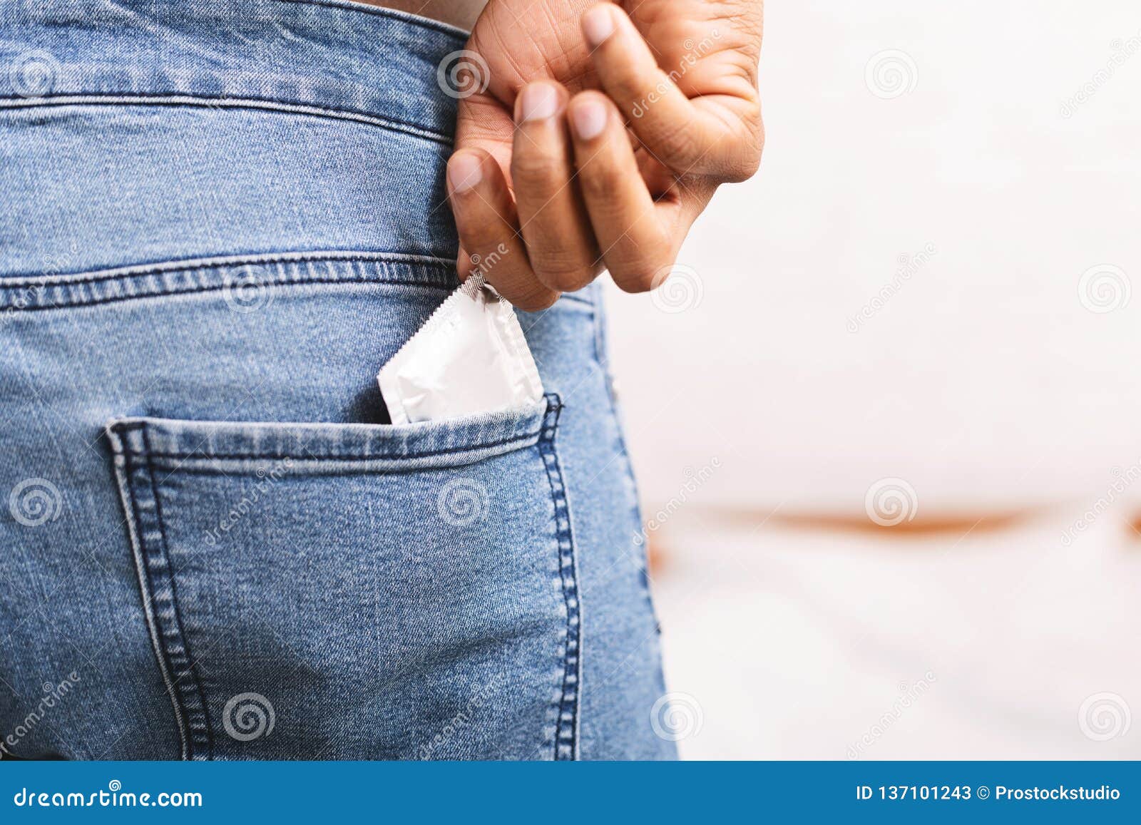 Man Taking Condom from Jeans Back Pocket Stock Image pic