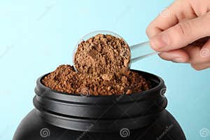 Man Taking Protein Powder With Scoop From Jar Against Color Background Man Taking Protein Powder With Scoop From Jar Against Color Background