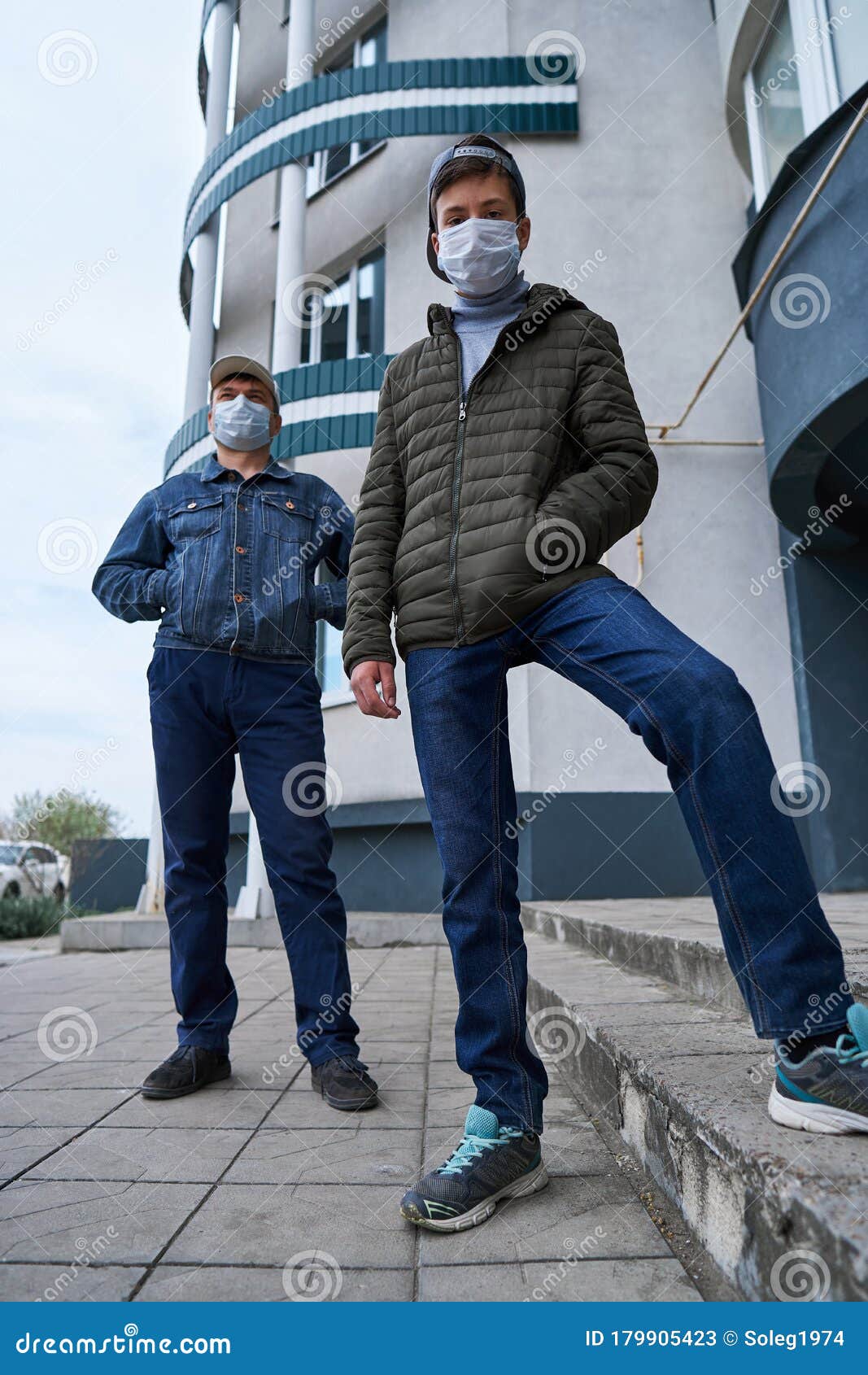 Man and Teen Boy Posing Near Wall and Closed Door of High-rise ...