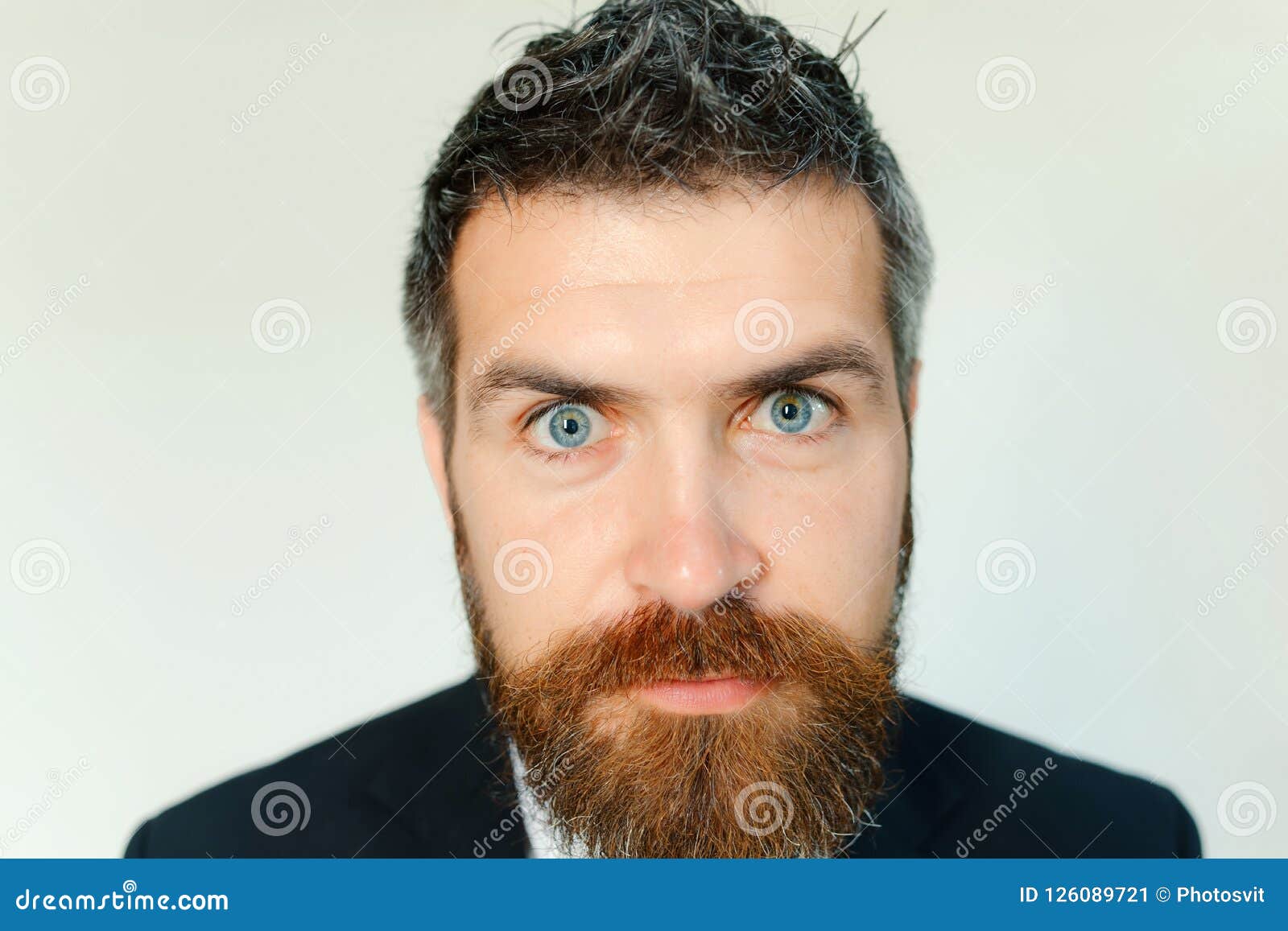 Man With Thick Beard And Blue Eyes On Grey Background Stock