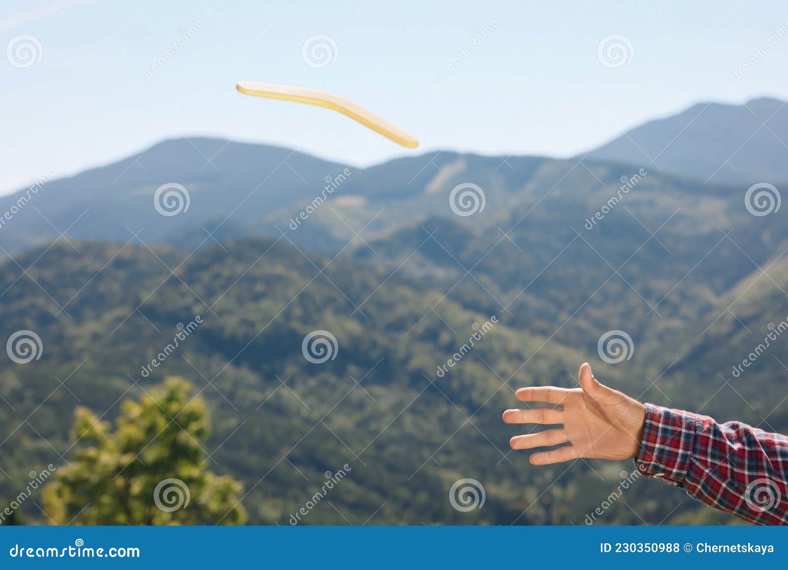 Man Throwing Boomerang in Mountains, Closeup View Stock Photo Image