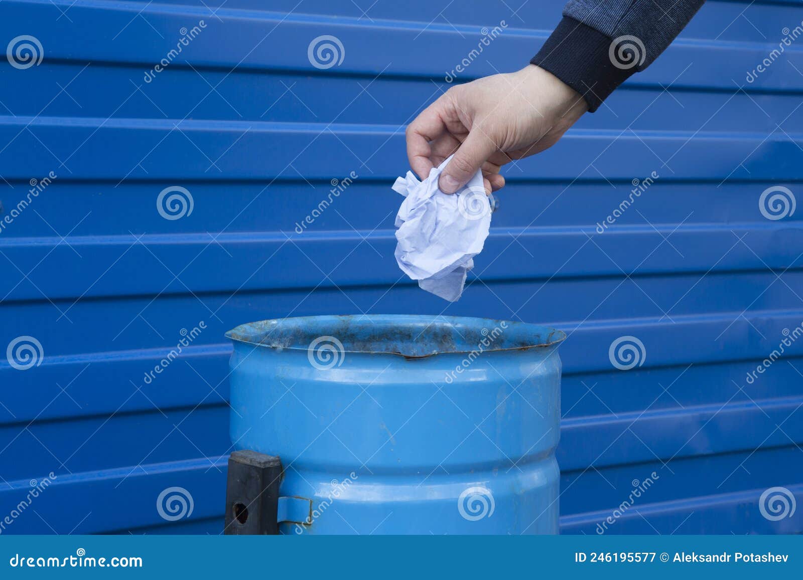 A Man Throws Garbage into a Trash Can on the Street.Hand Closeup Stock