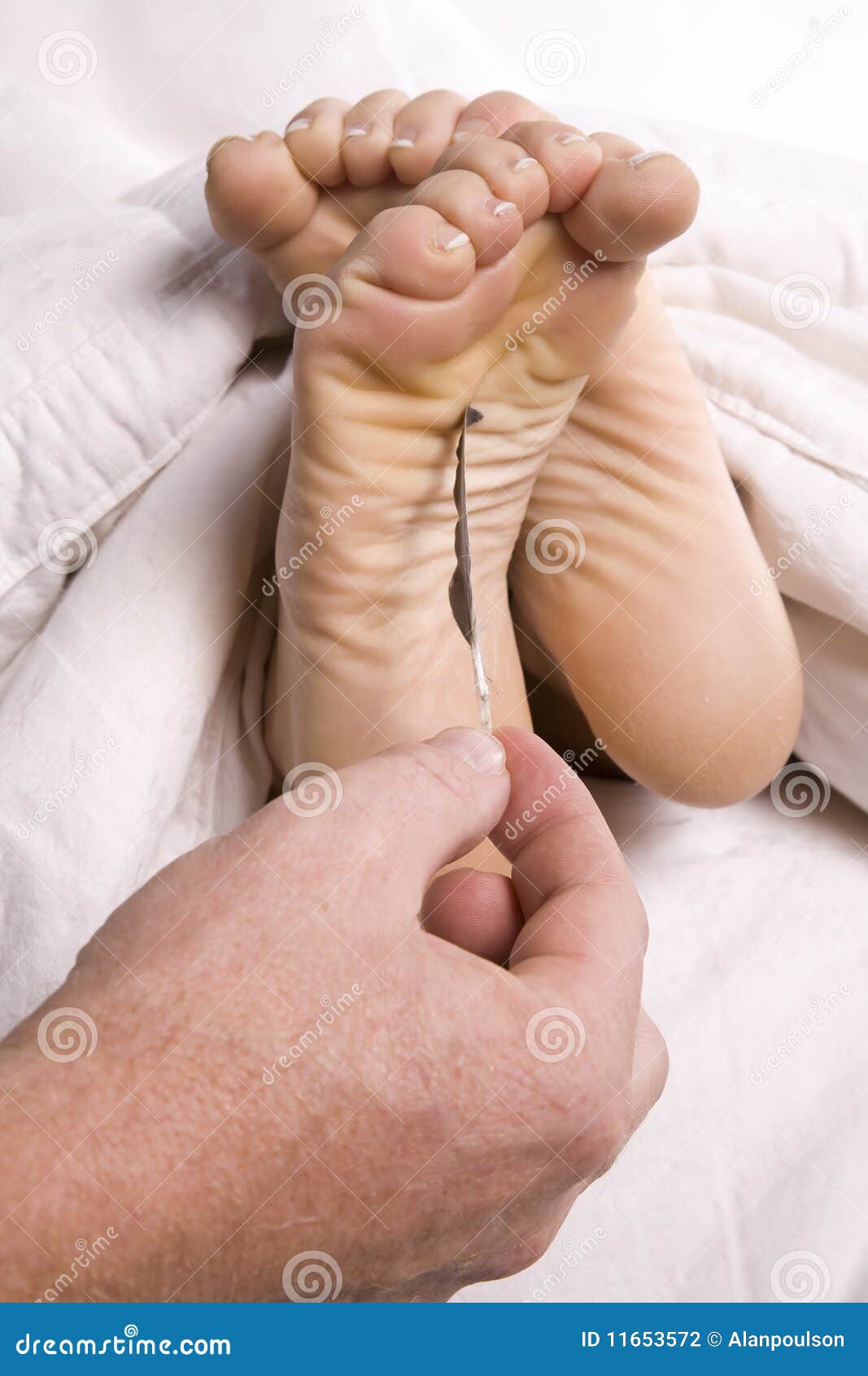Man tickling womans feet stock photo