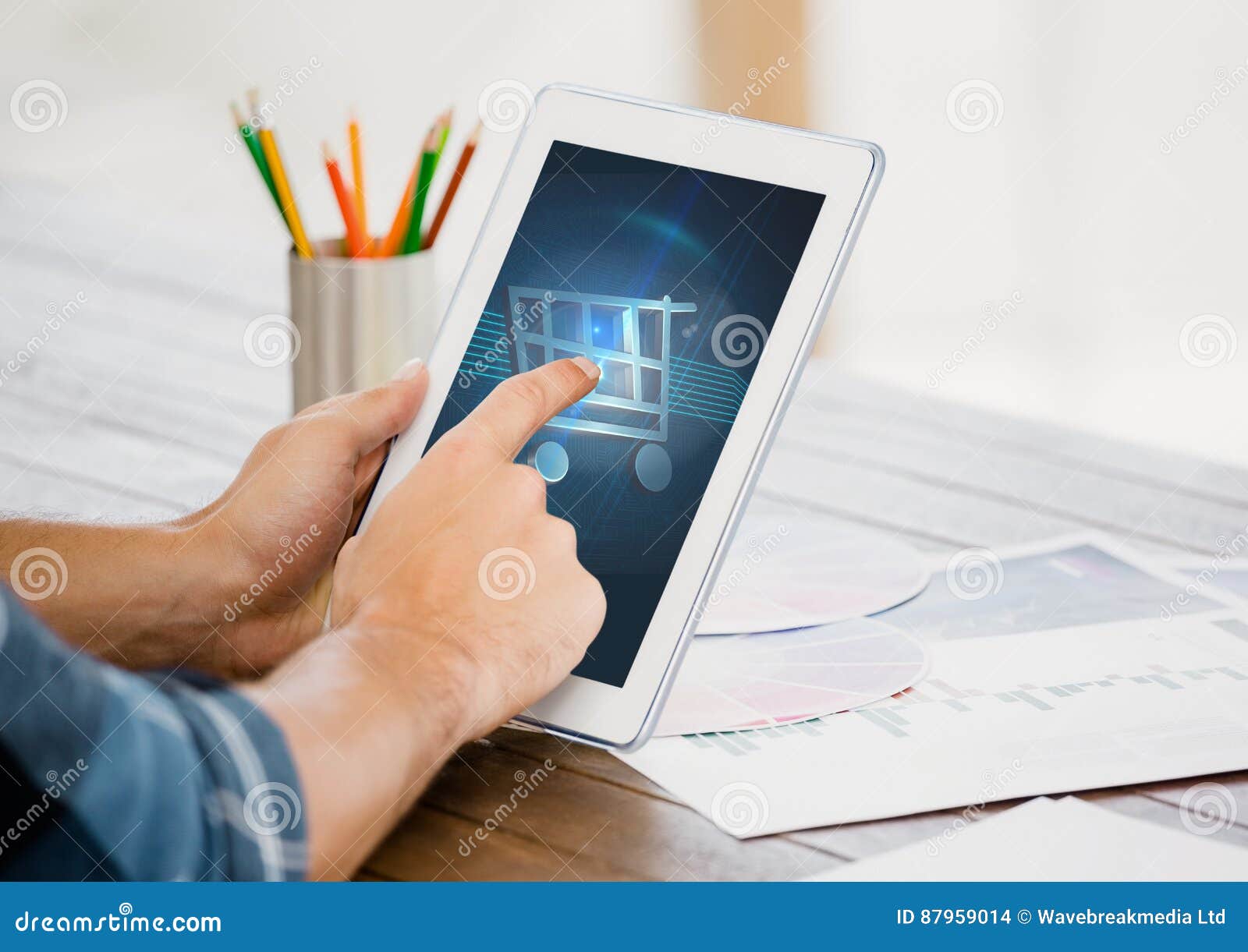 man touching shopping cart icon on digital tablet