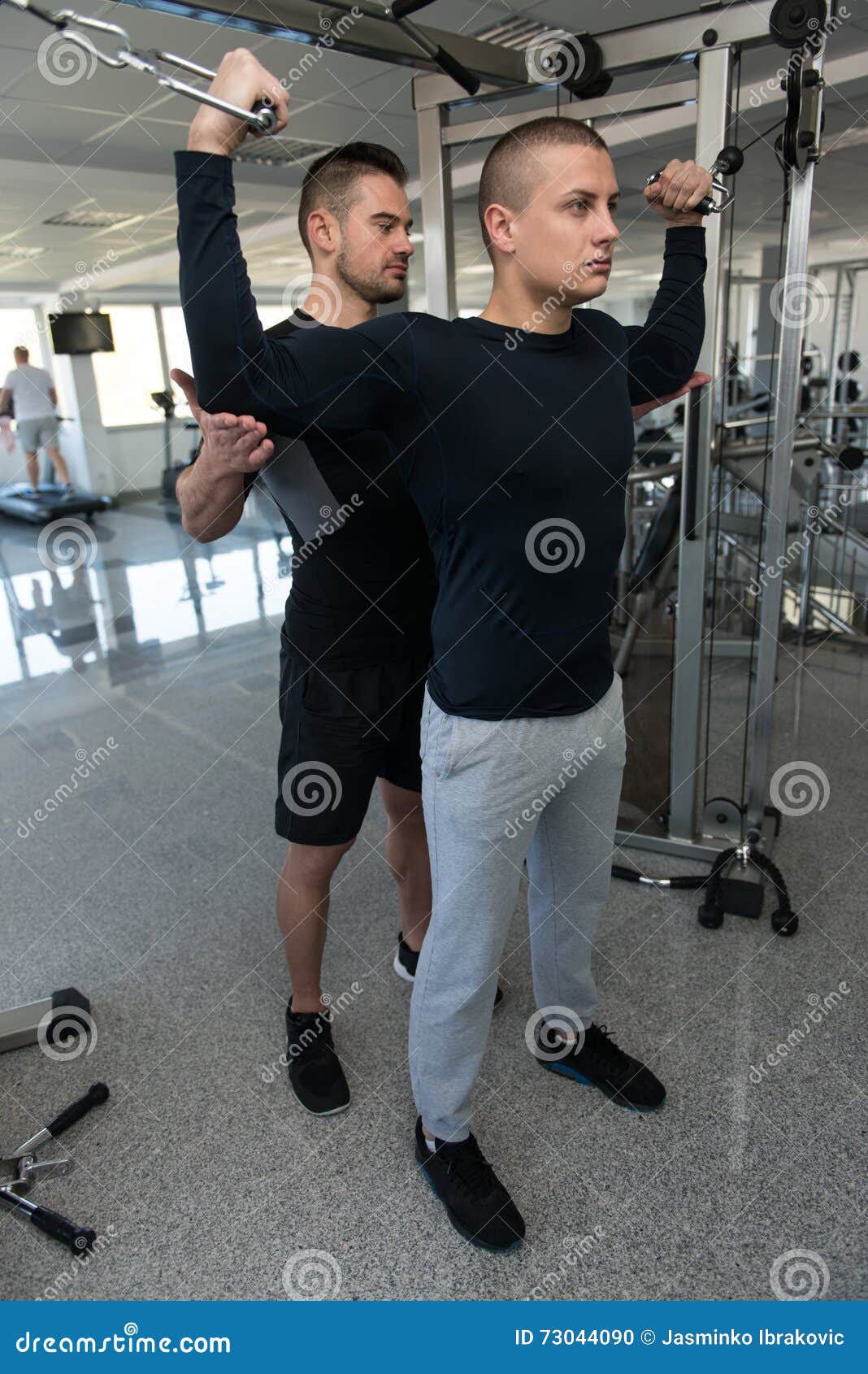 Man Train Biceps on Machine with Personal Trainer Stock Photo Image