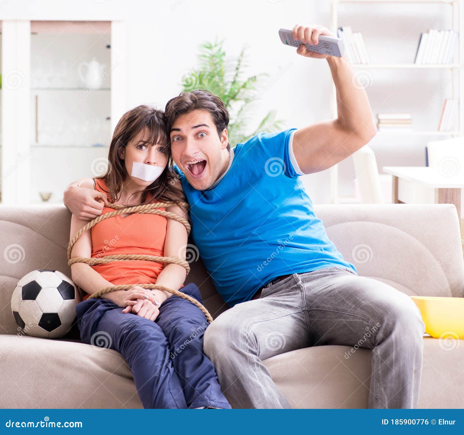 Man Tying Up His Wife To Watch Sports Football Stock Photo wife hq photo Man Tying Up His Wife To Watch Sports Football Stock Photo