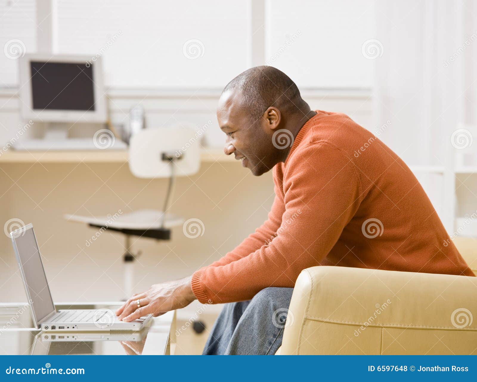 man typing on laptop in livingroom