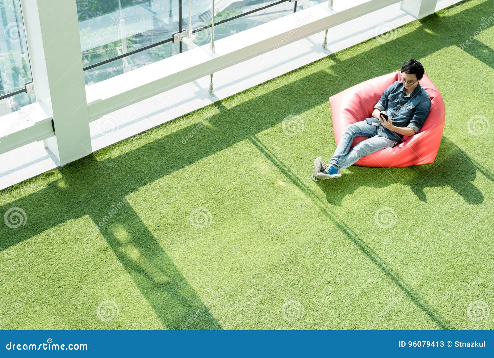 man use smartphone on bean bag in afternoon, freelance conceptual lifestyle, internet in everyday life