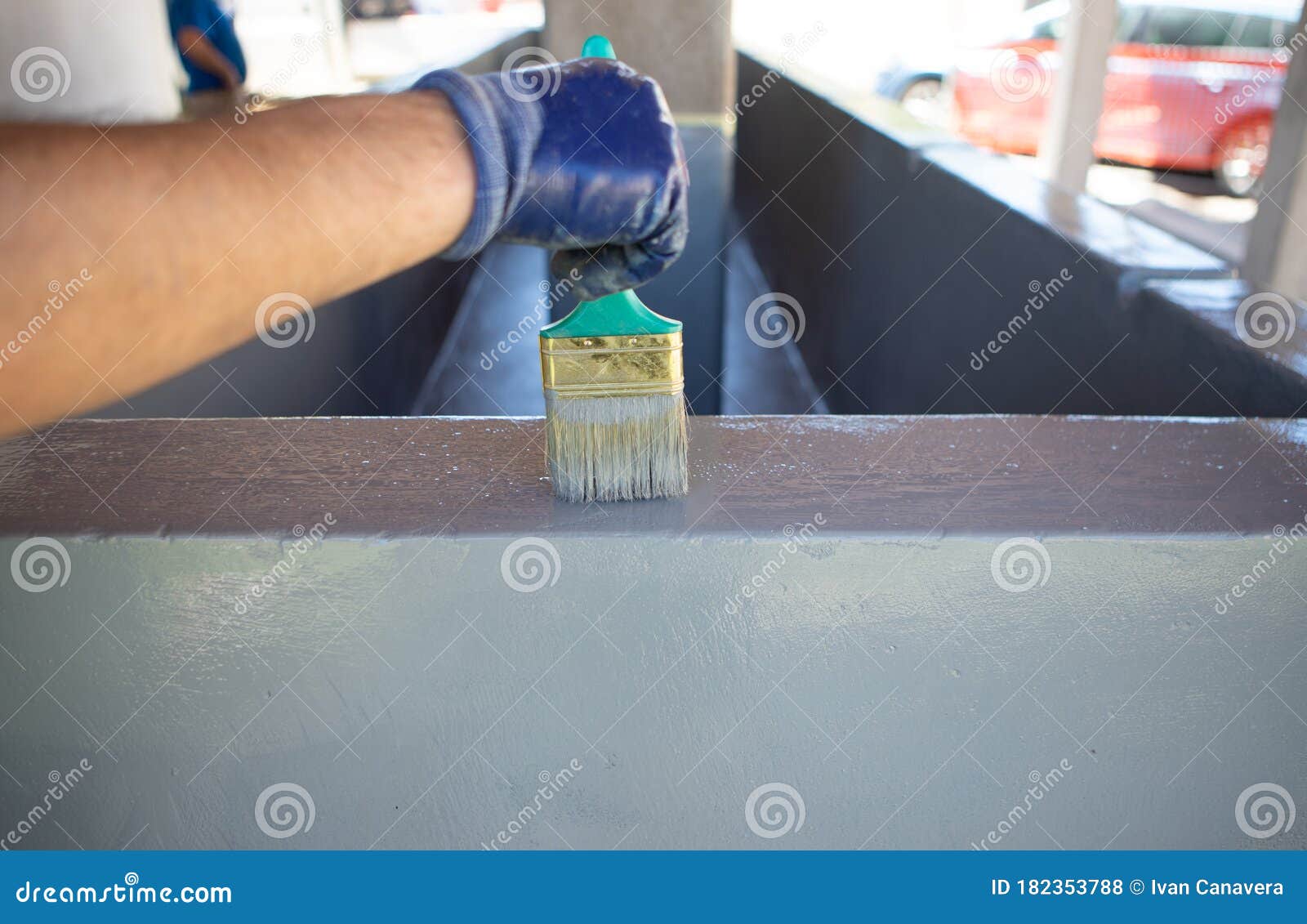 man using a brush to paint a swimming pool