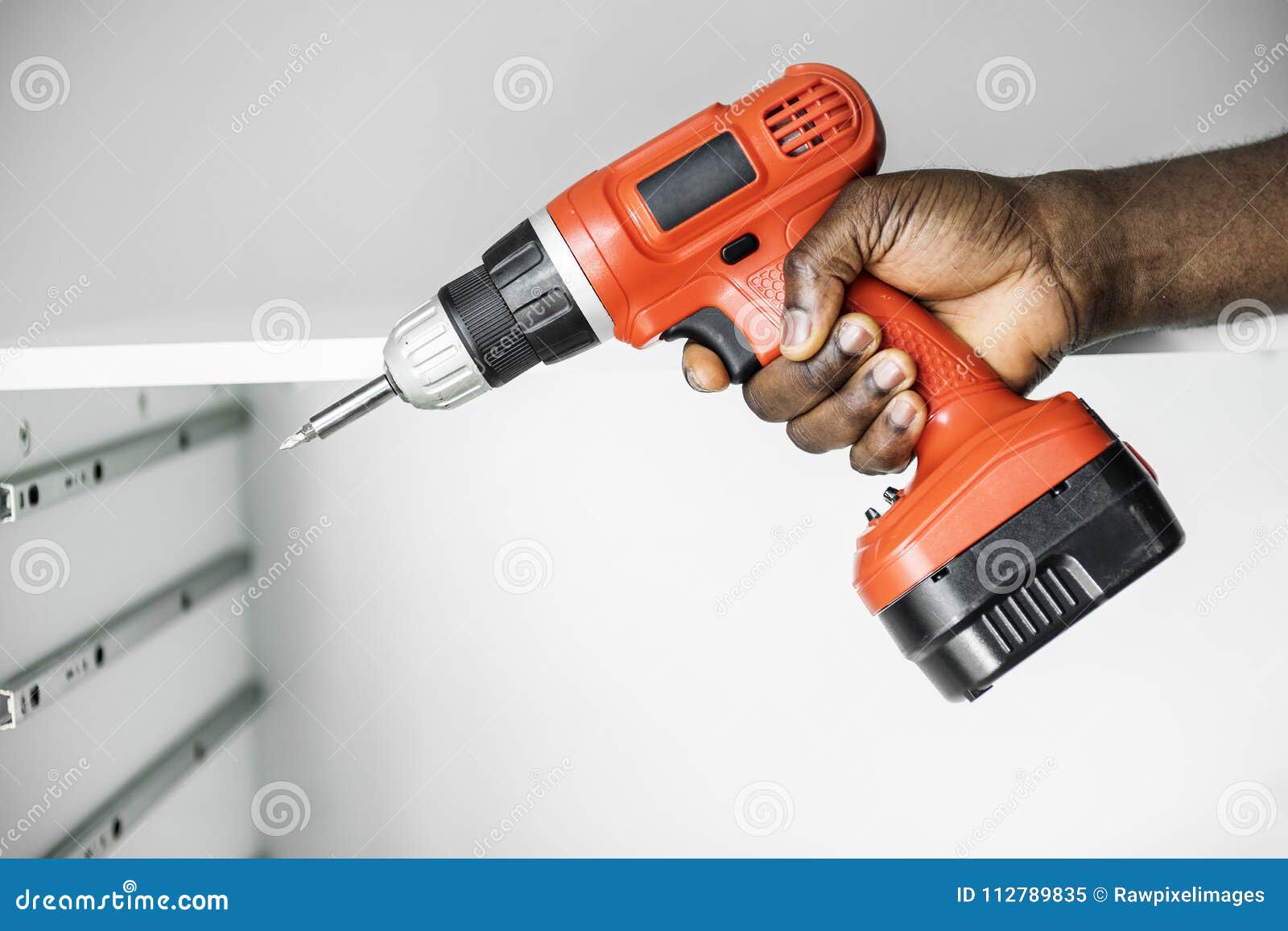man using electronic drill install cabinet